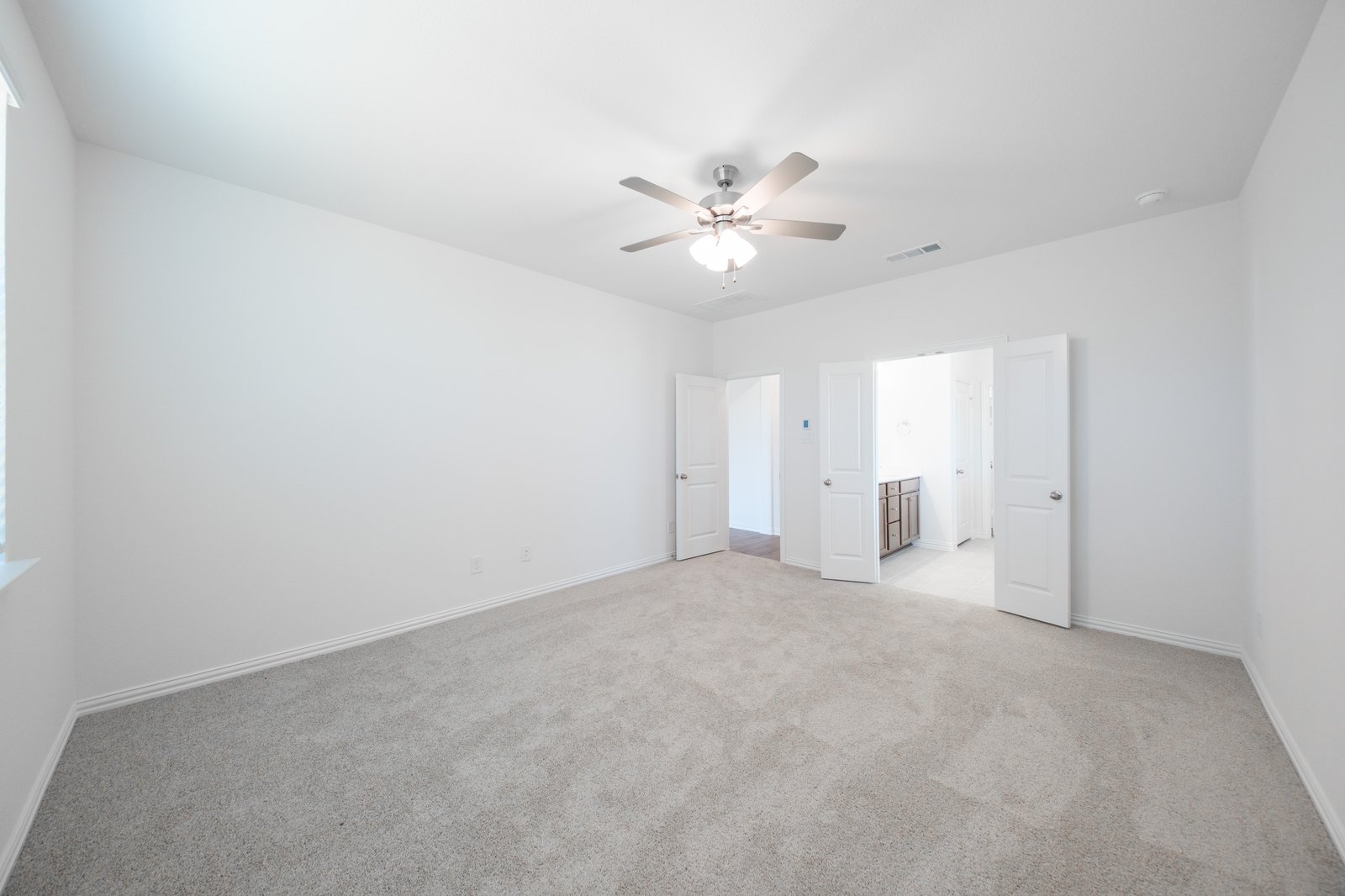 primary bedroom with carpet and ceiling fan