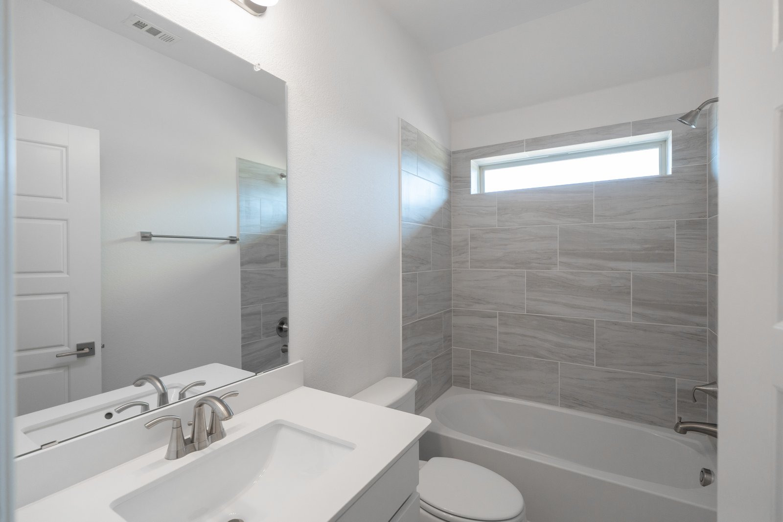 bathroom with tub and white countertops