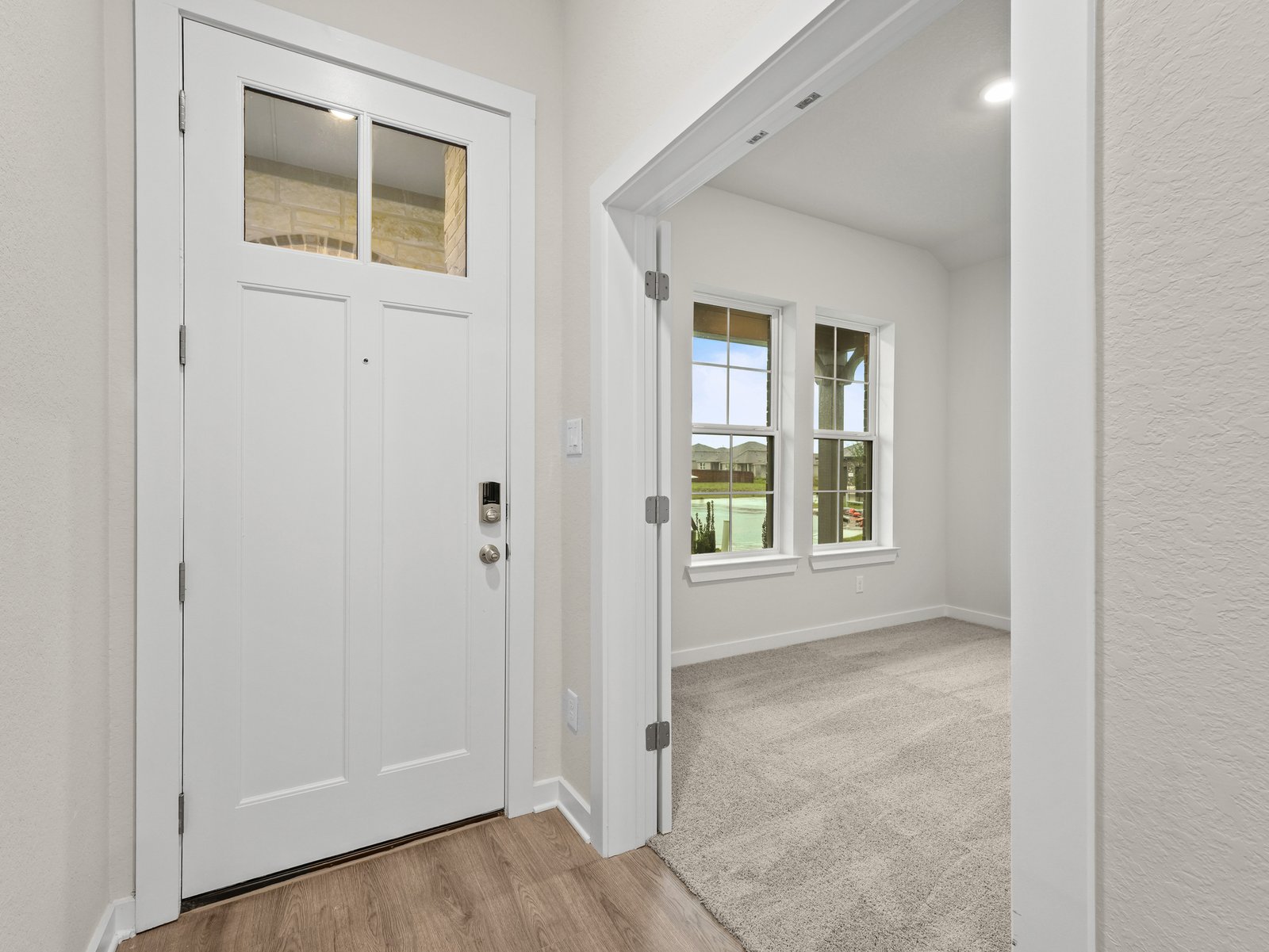 foyer with door, brown flooring and entrance to the study