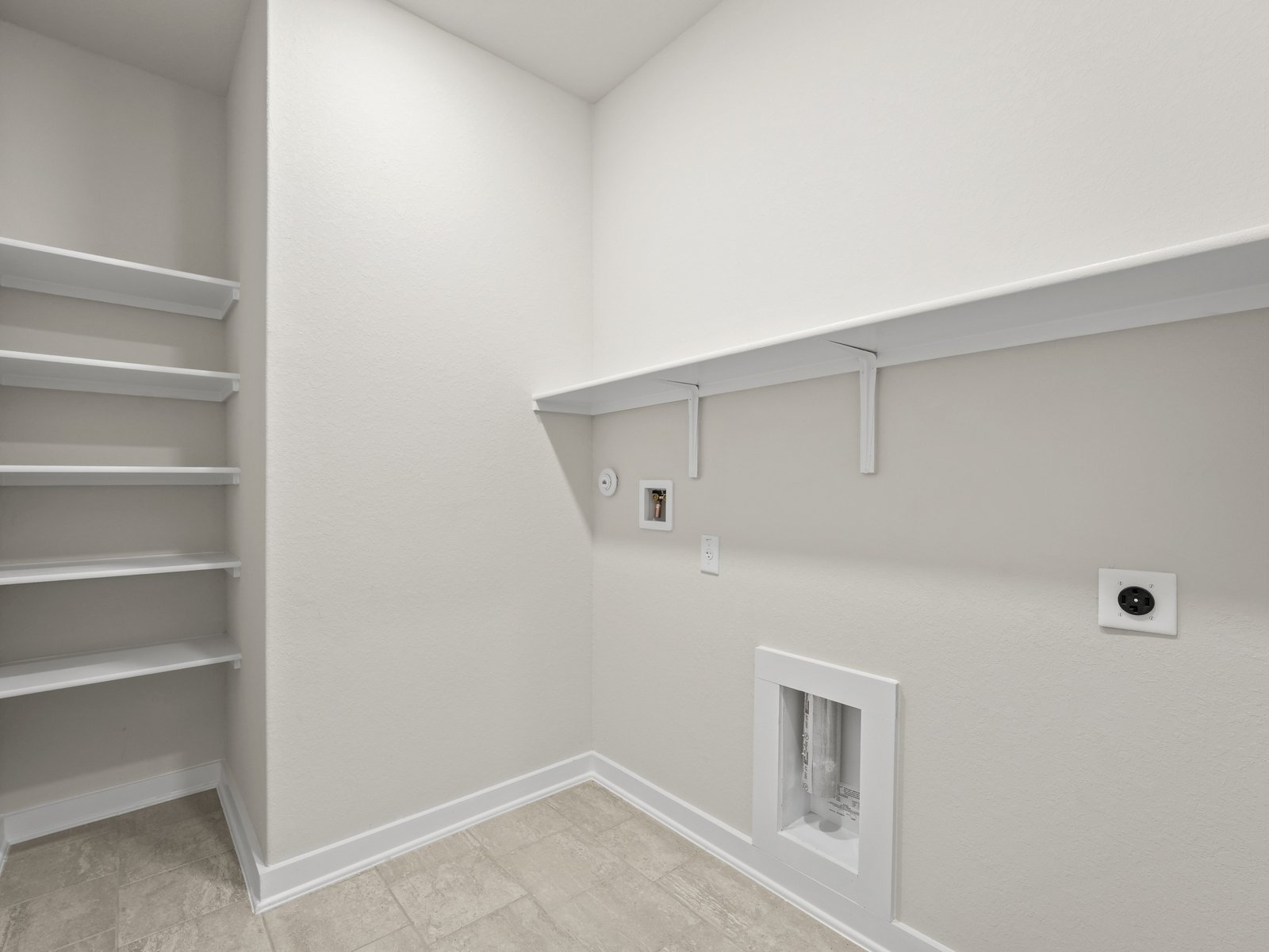 laundry room with white floor and white shelving