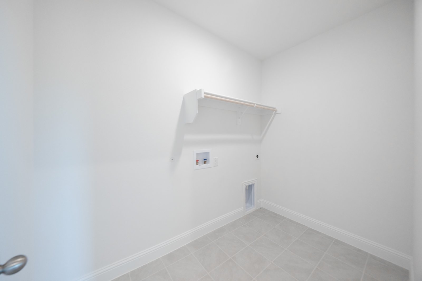 laundry room with tile floors and white shelf