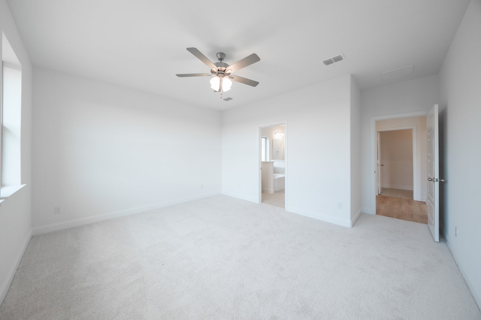 primary bedroom with carpet and ceiling fan