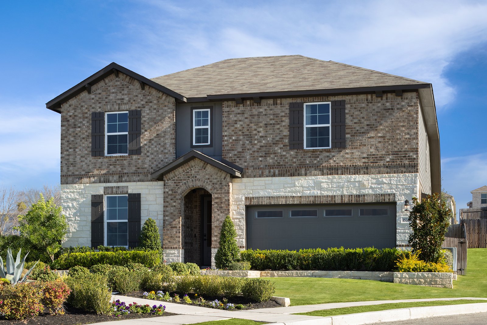 exterior with brick, tree & a 2-car garage