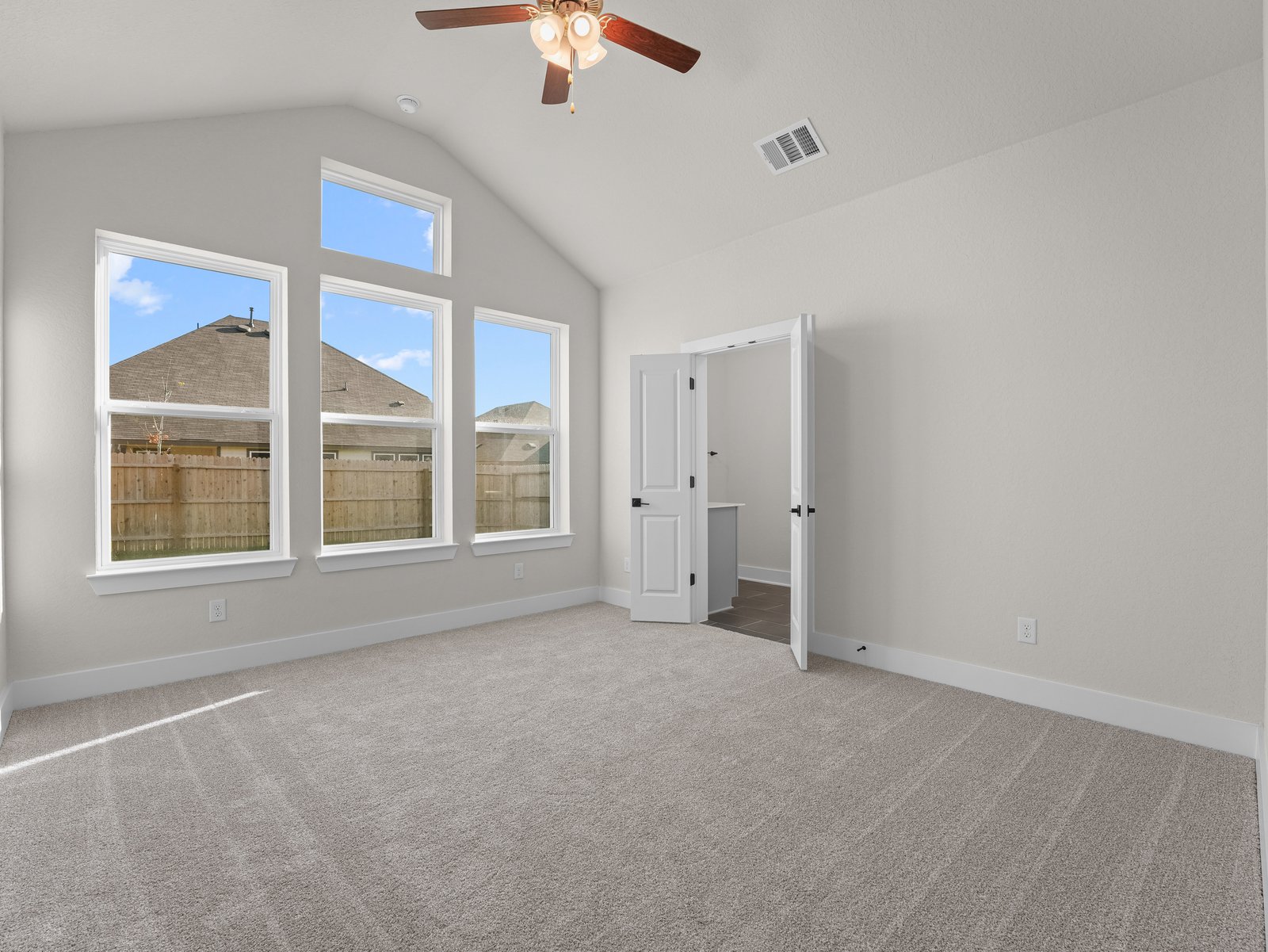 primary bedroom with carpet, windows and a ceiling fan