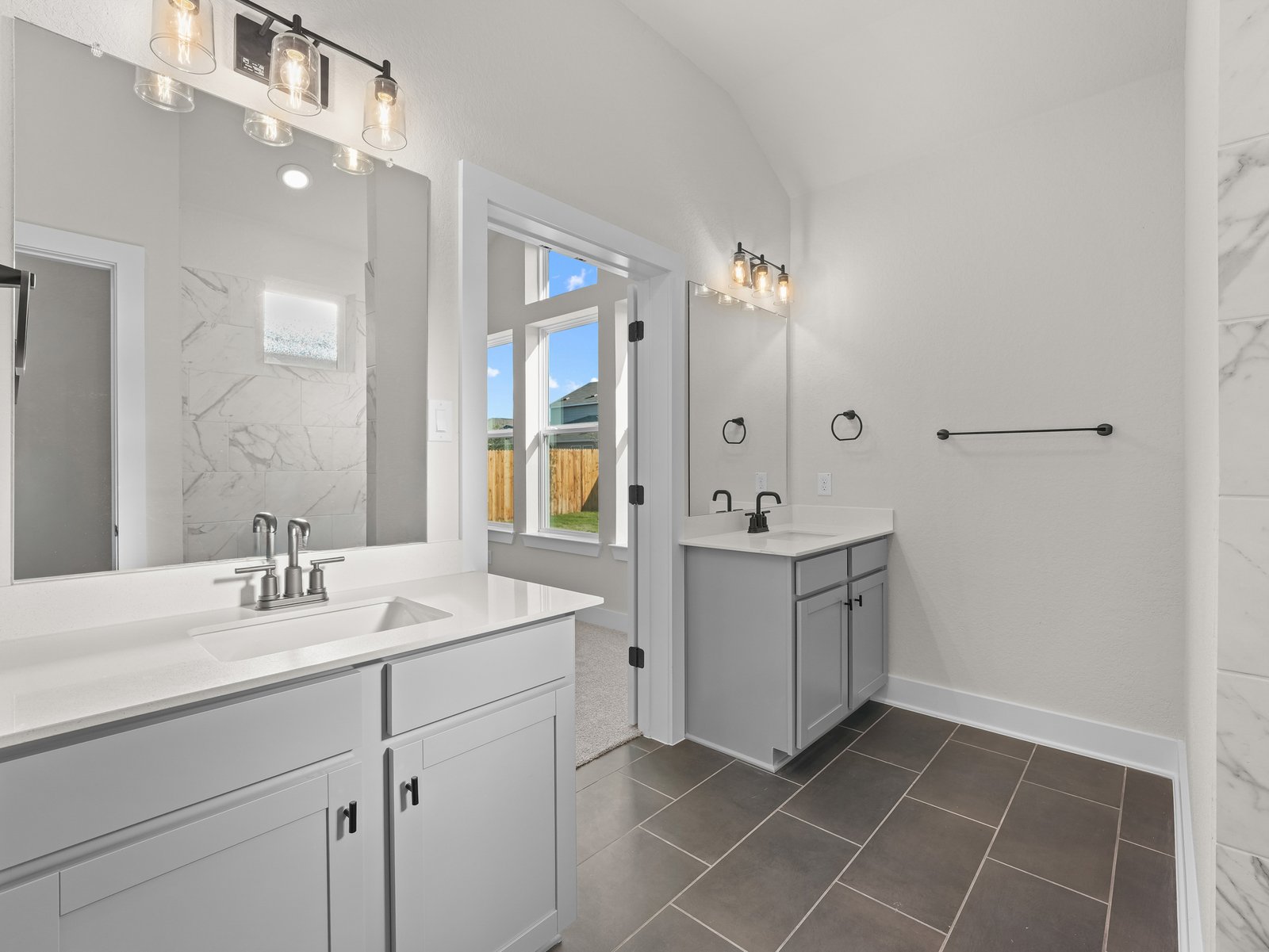 primary bathroom with dual sinks and a walk-in shower