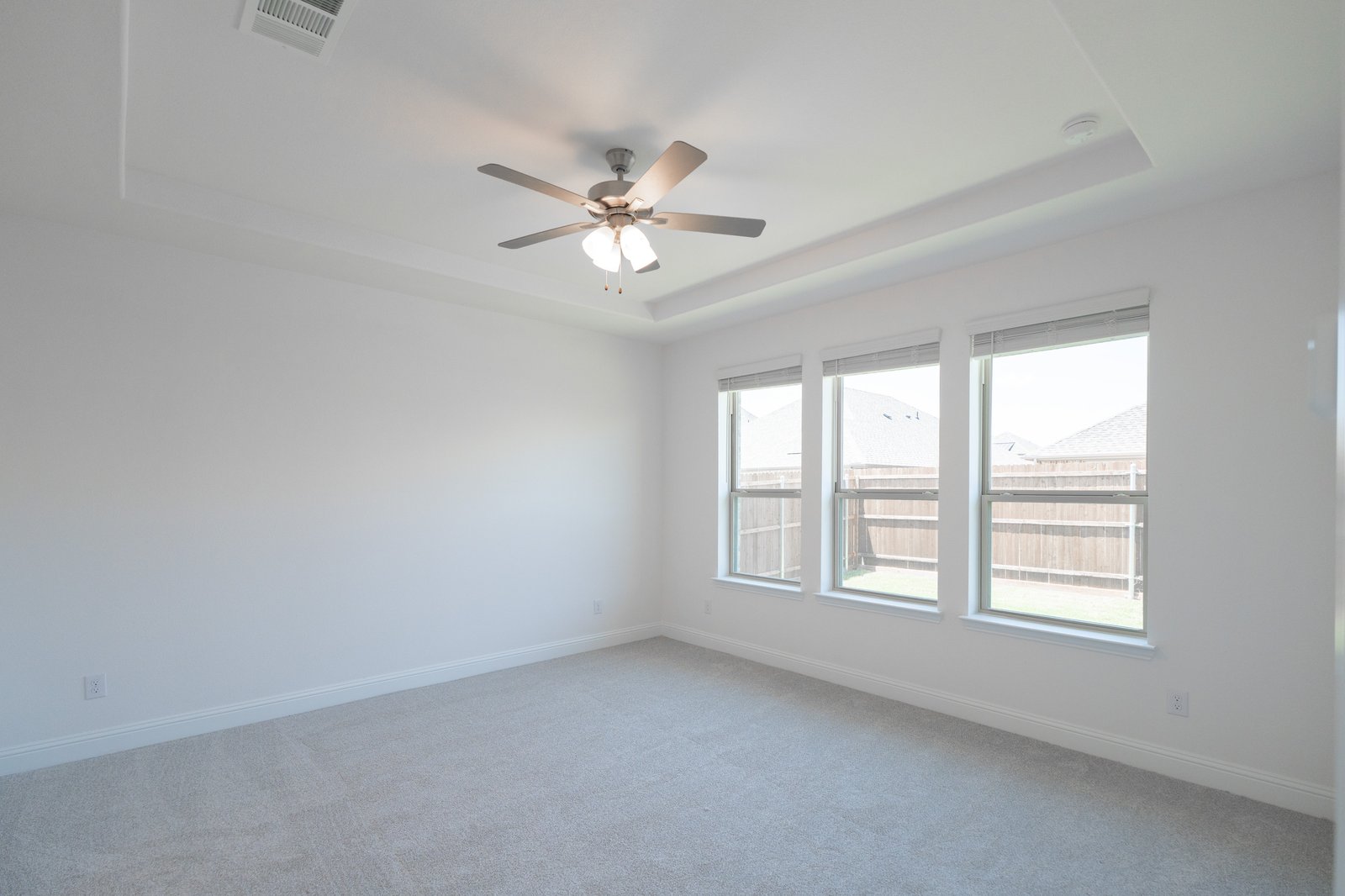 bedroom with large widows and tray ceilings 