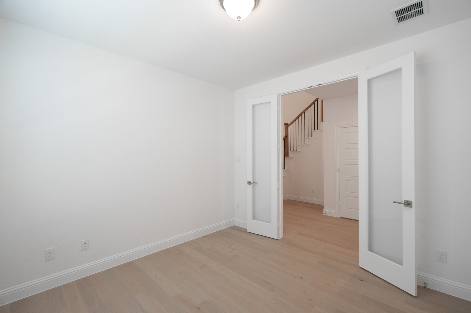 study with wood flooring and french doors 