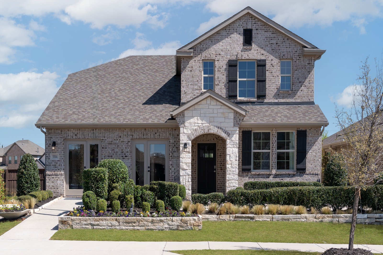 model home with brown brick and white stone