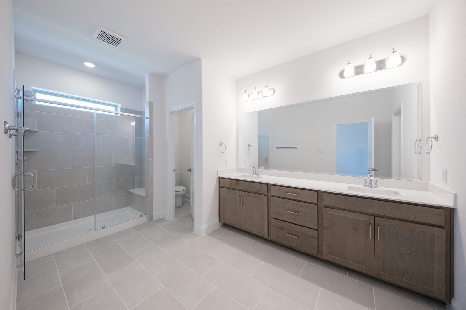 primary bathroom with walk-in shower and tile floors
