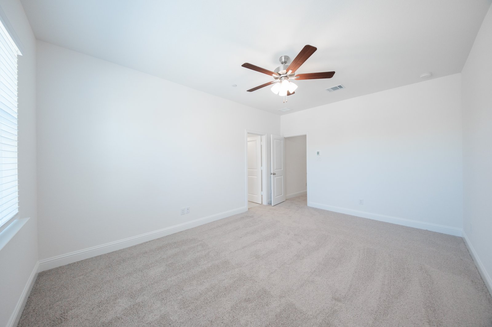 primary bedroom with carpet and ceiling fan