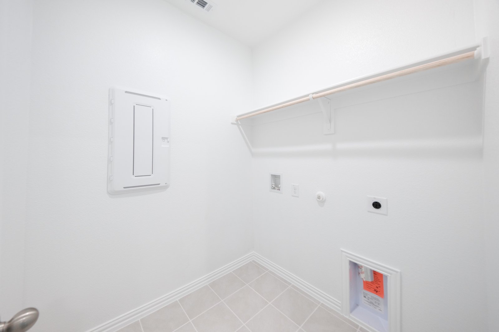 laundry room with tile floors and white shelf