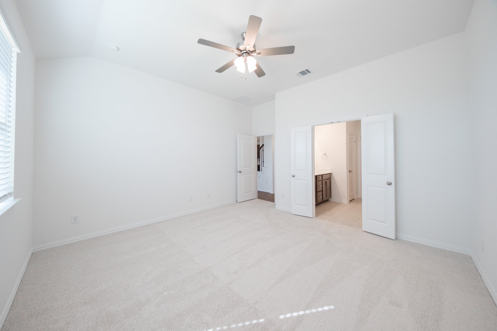 primary bedroom with carpet and ceiling fan