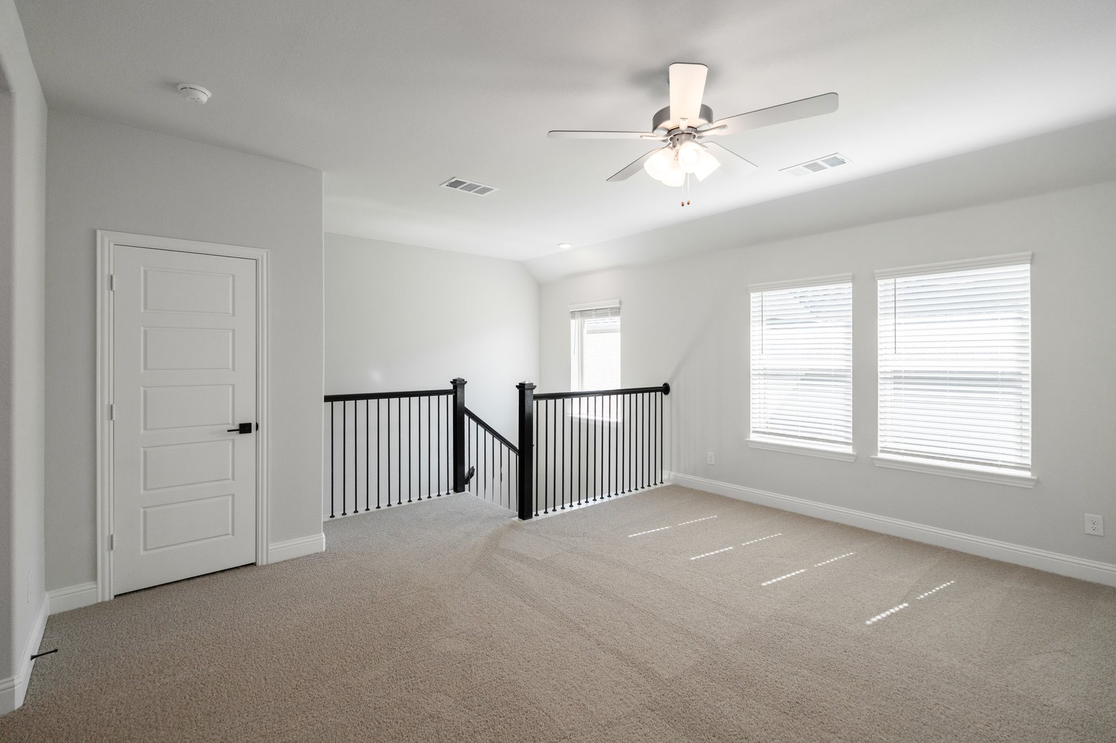 open loft with carpet, window, and ceiling fan
