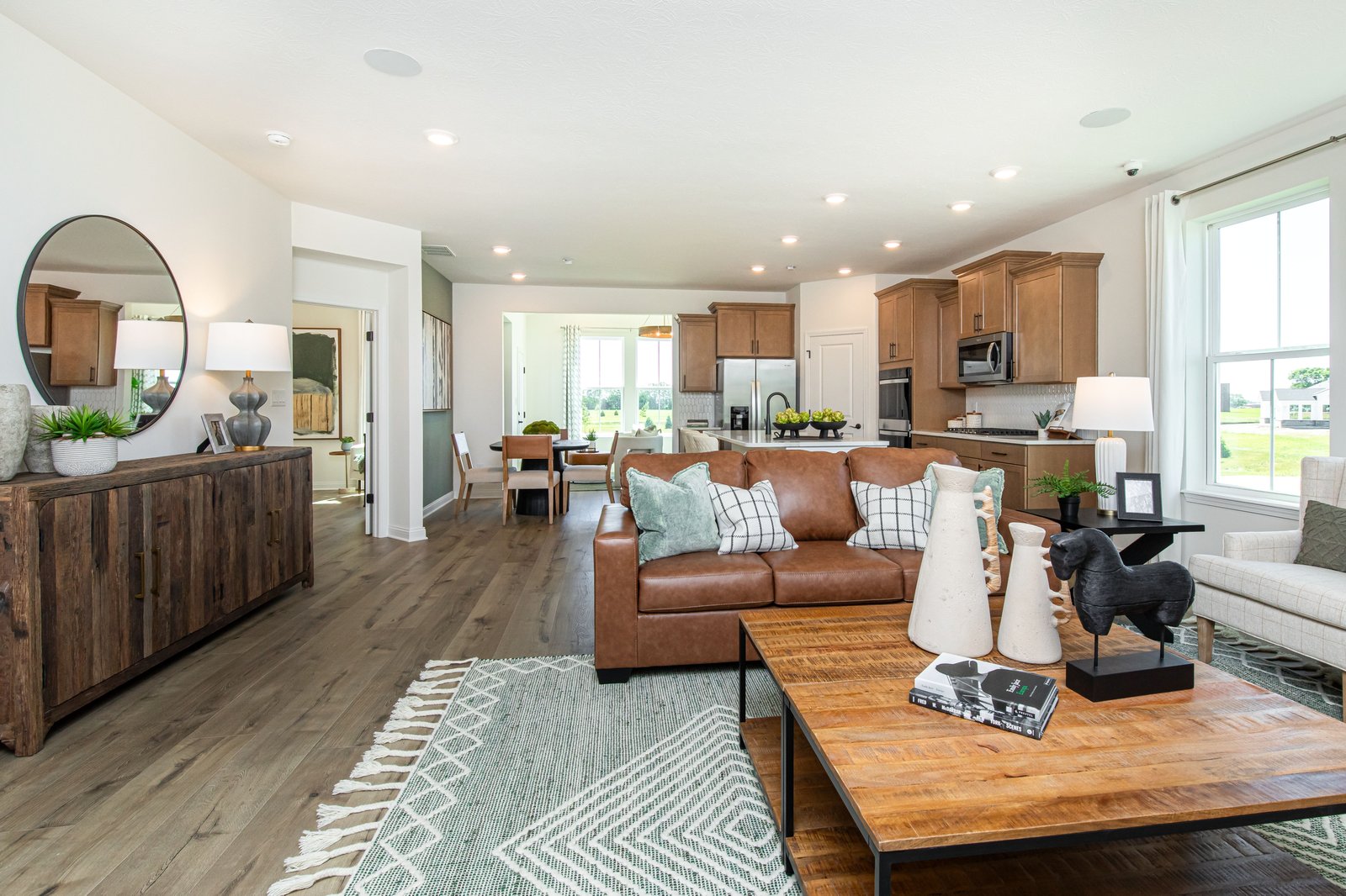 great room with wood plank flooring and open concept to the kitchen