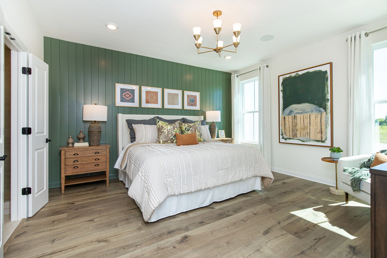 bedroom with wood plank flooring and green accent wall