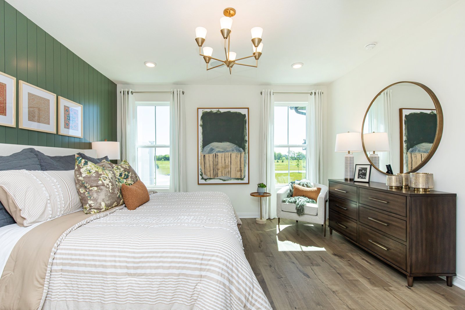 bedroom with green accents and windows letting in natural light