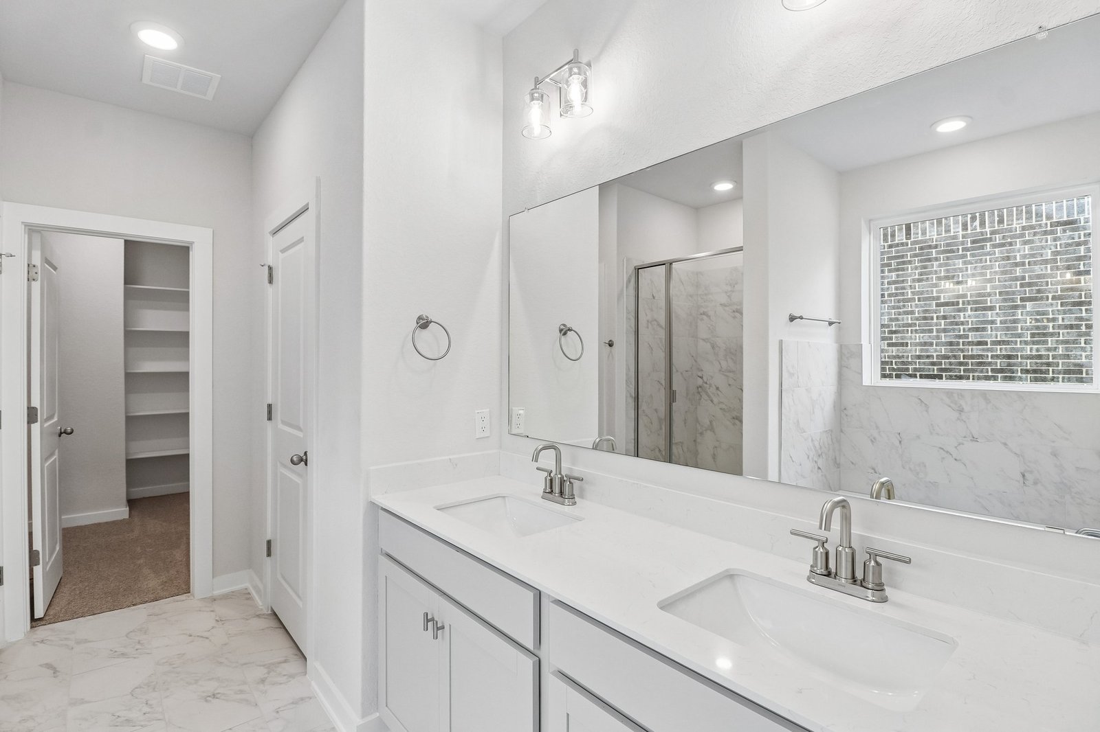 primary bath with dual sinks and white flooring