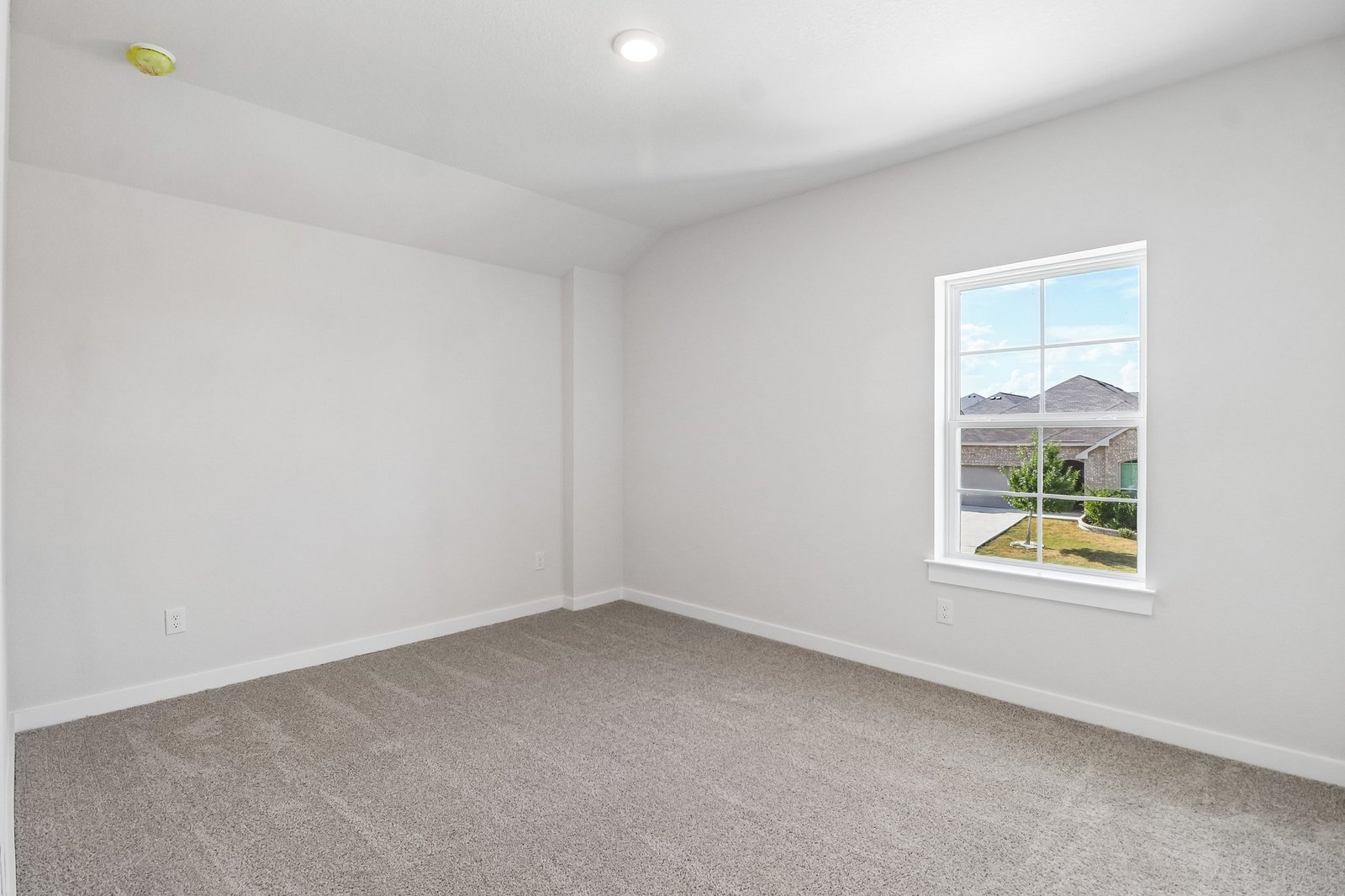 secondary bedroom with carpet, window and a sloped ceiling
