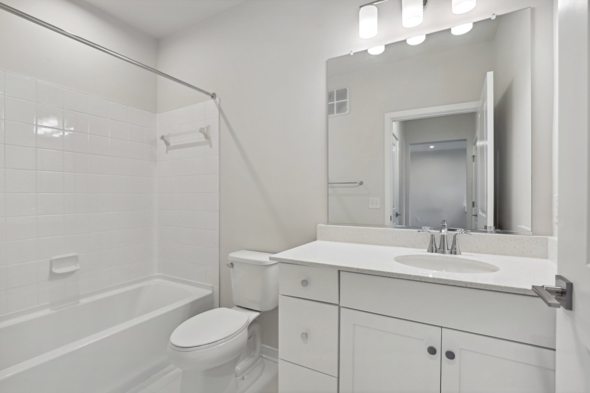 secondary bathroom with sink, shower, tub and white cabinets