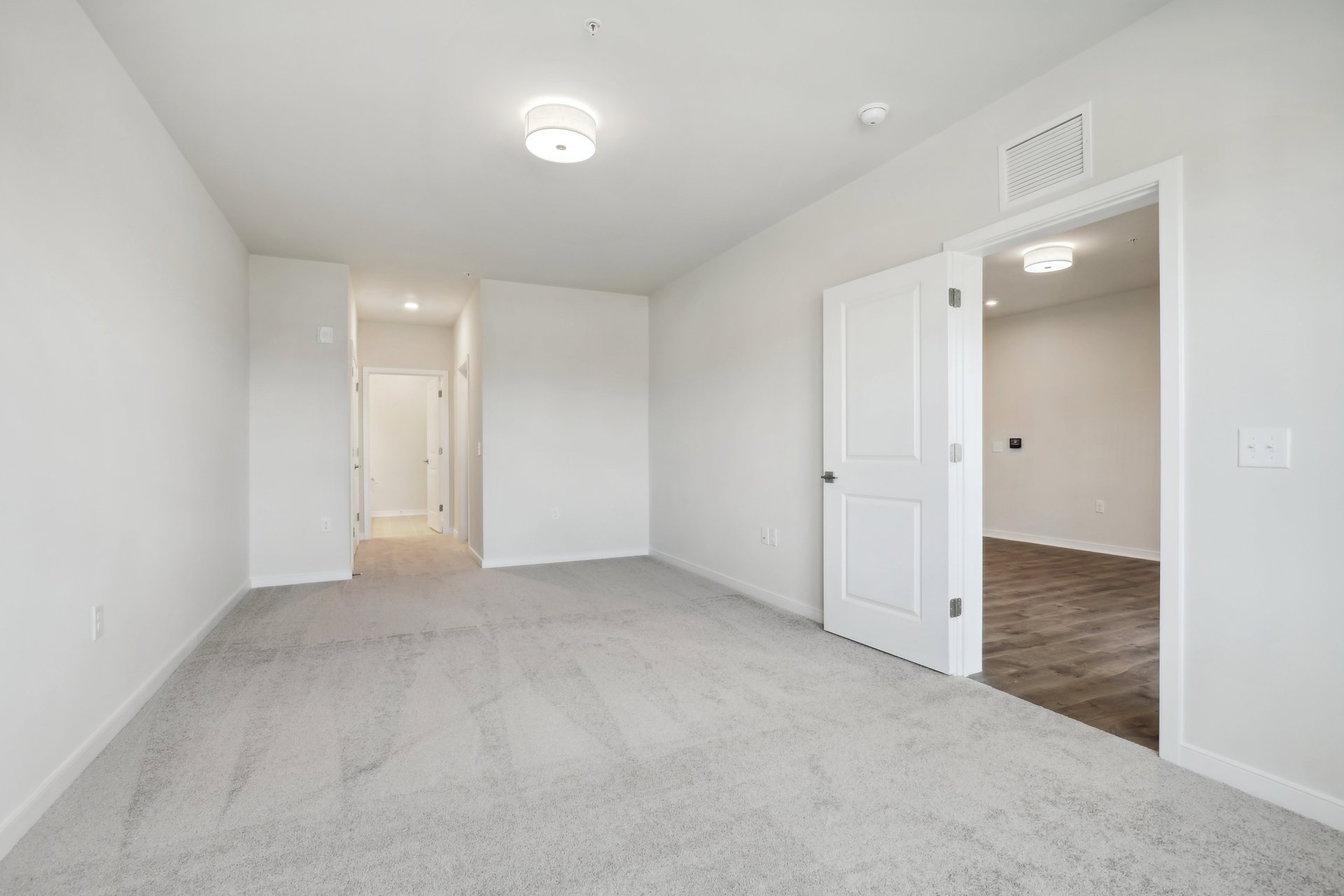 secondary bedroom with hallway to bathroom and door to great room