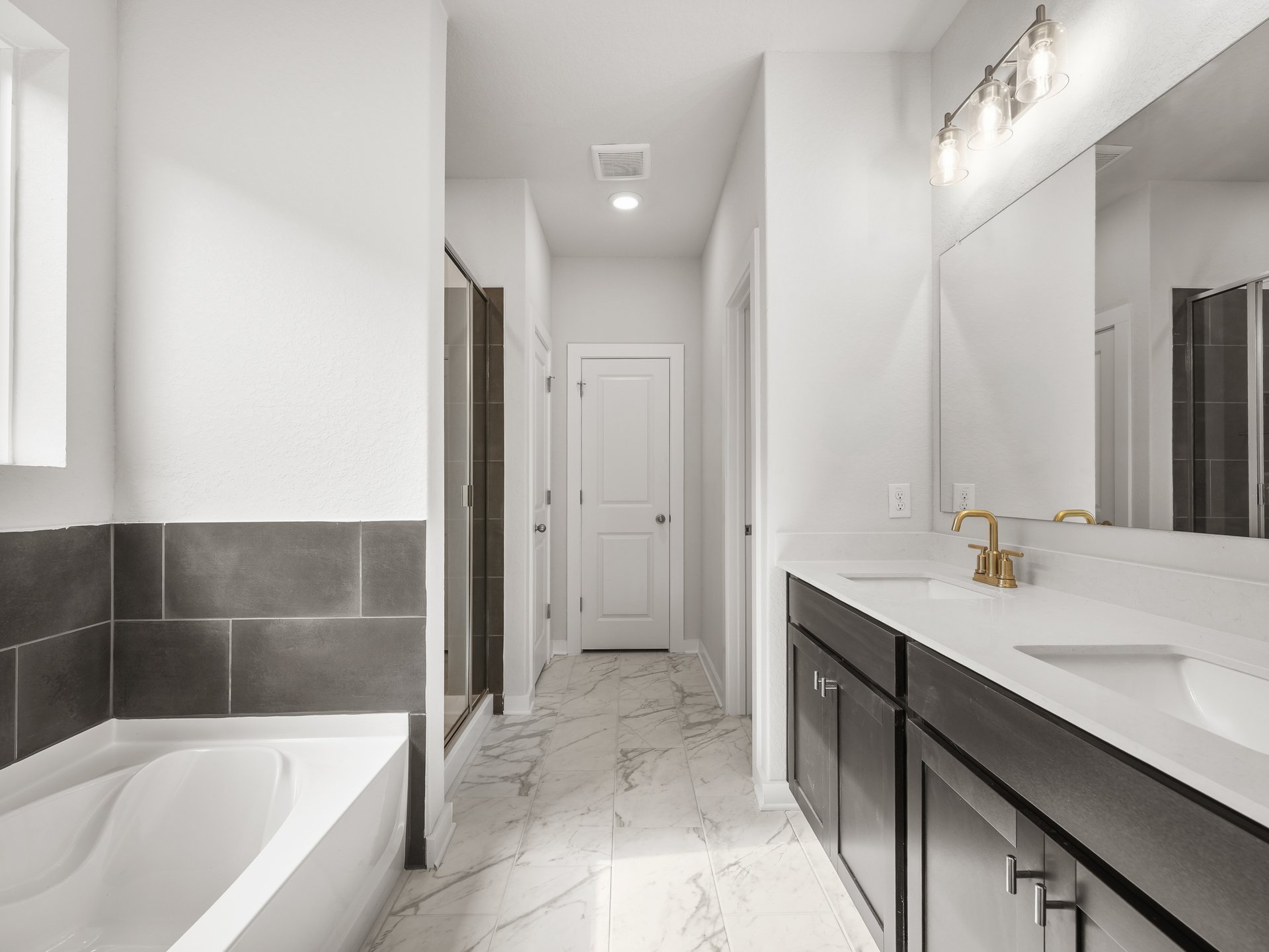 primary bathroom with dual sinks, soaking tub abd walk-in shower 