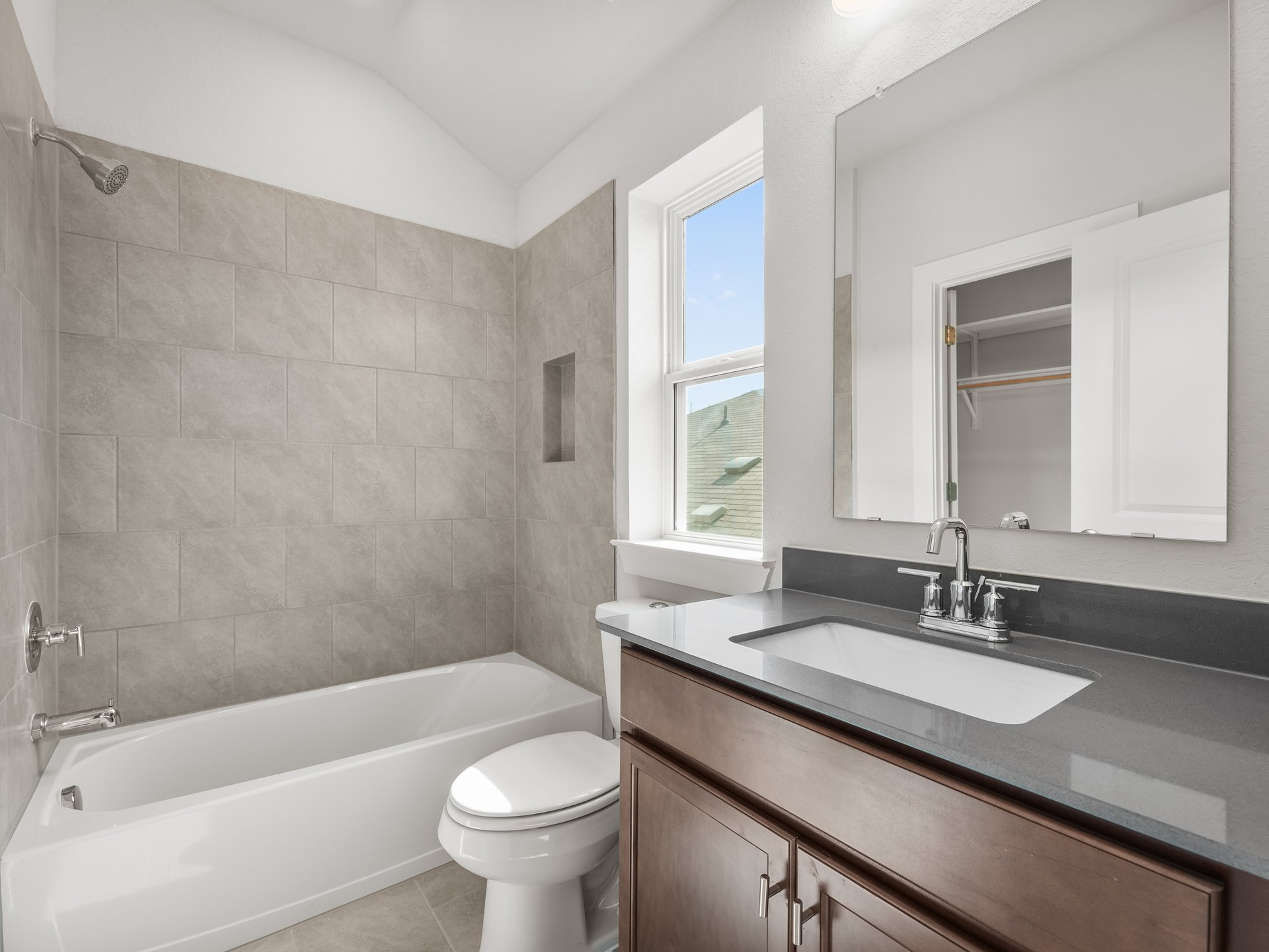 secondary bathroom with sink, soaking tub and window
