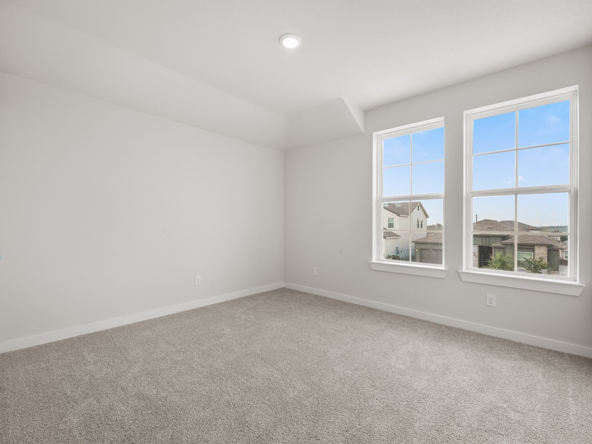 secondary bedroom with dual windows, carpet and pendant lighting 