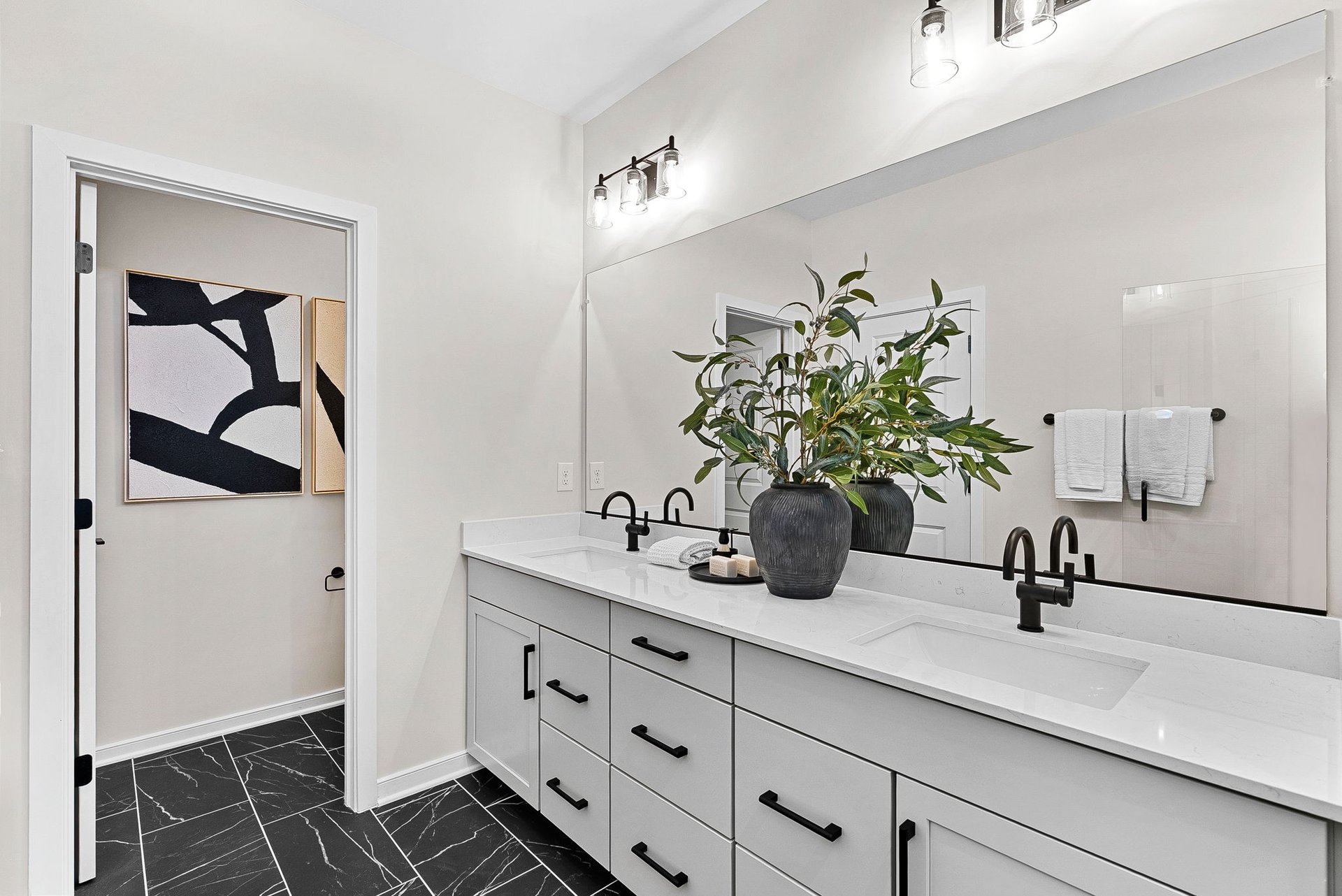 primary bathroom with two sinks and a toilet room