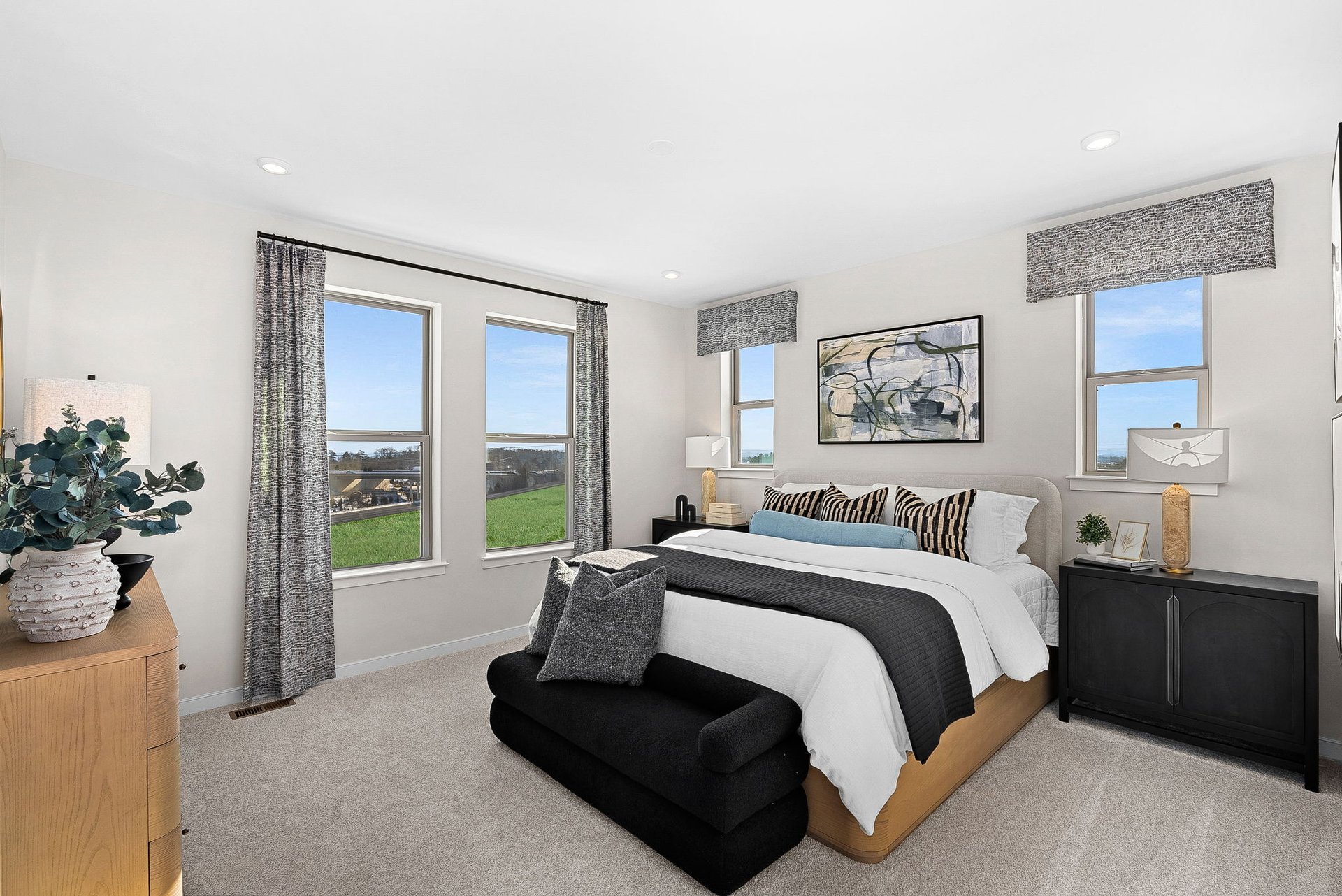 carpeted primary bedroom with multiple windows