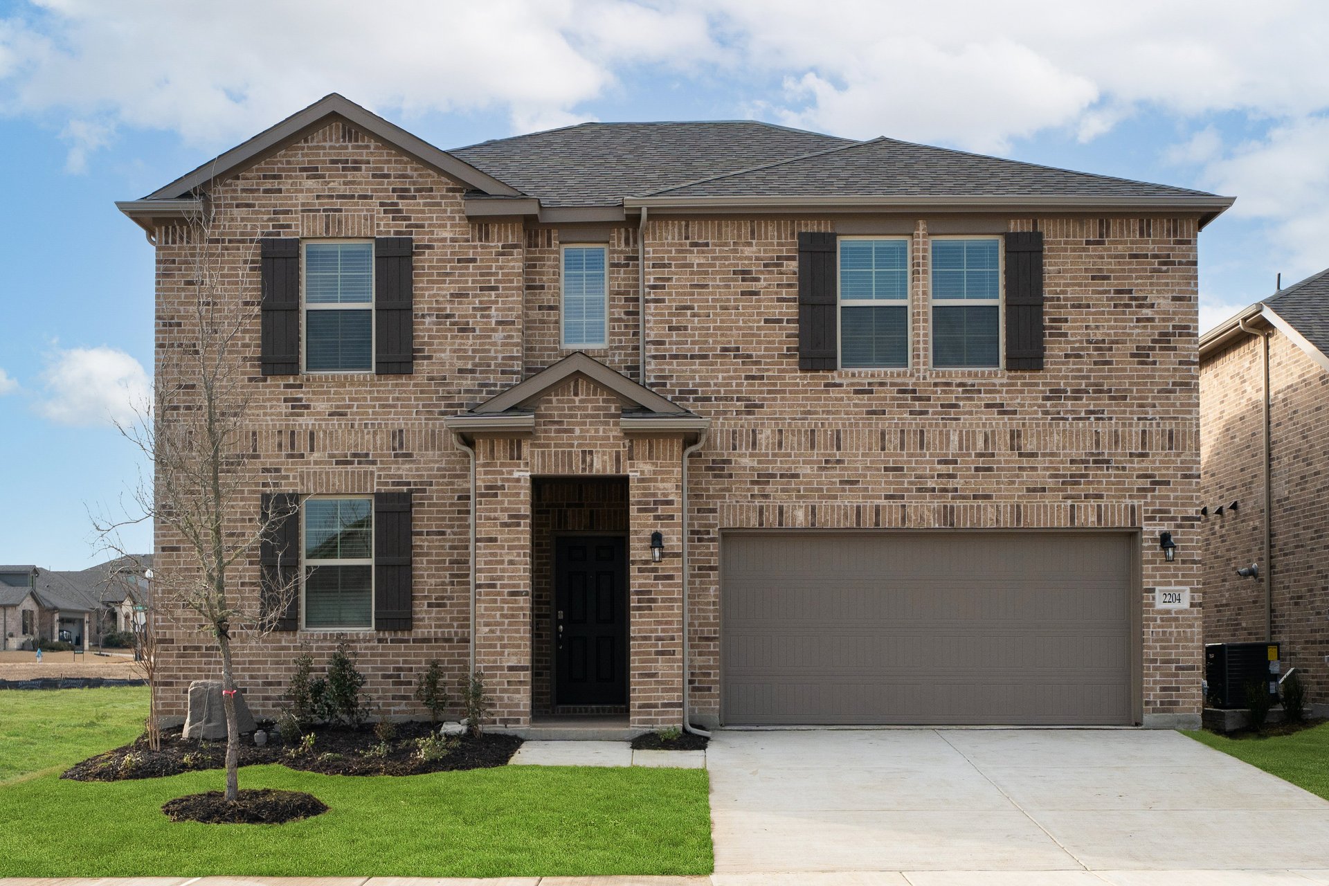 two-story home with brick and shutters