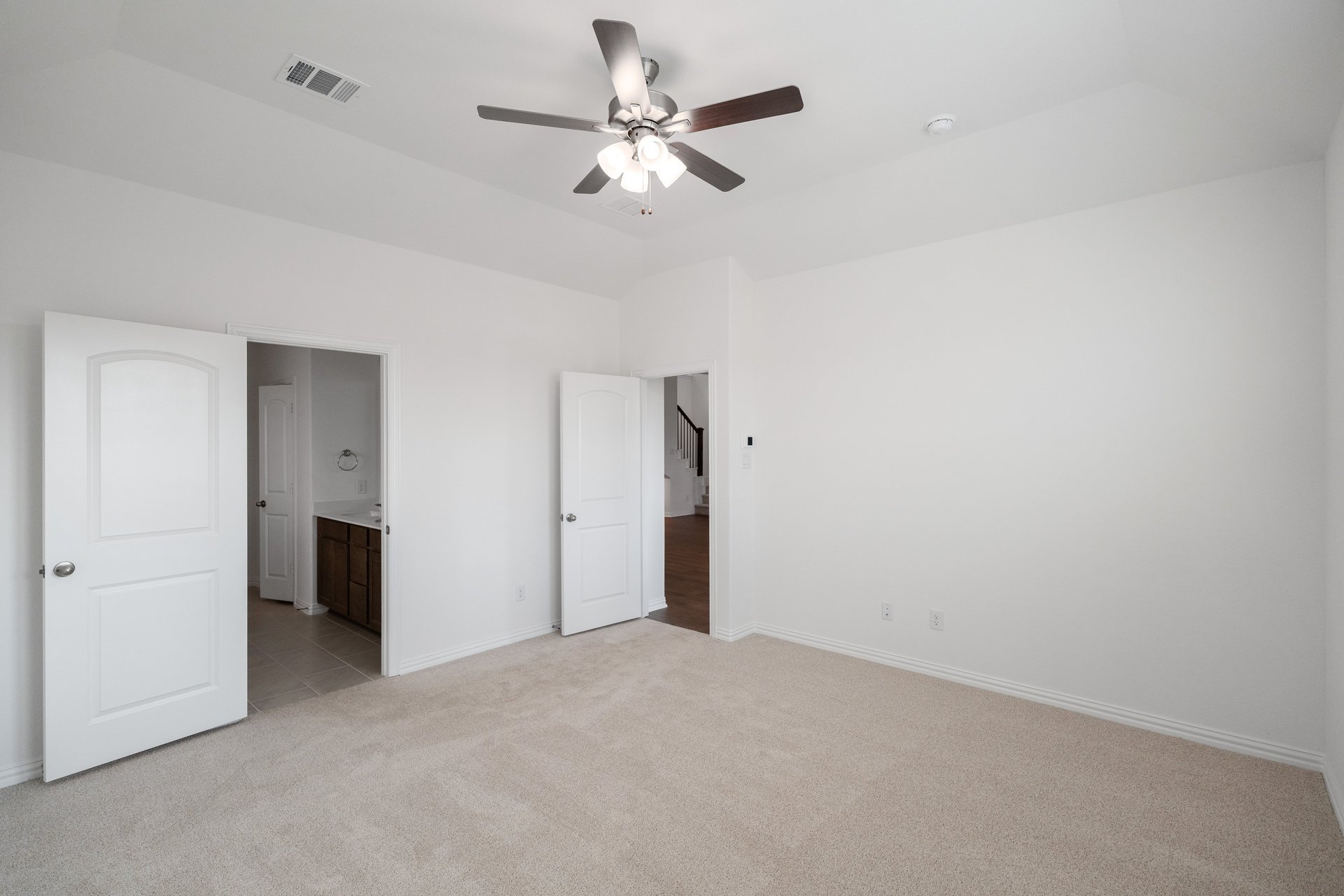 primary bedroom with carpet and ceiling fan