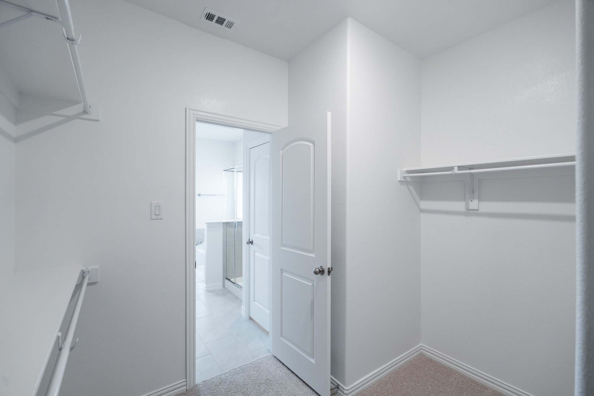 primary bedroom closet with carpet and white shelves