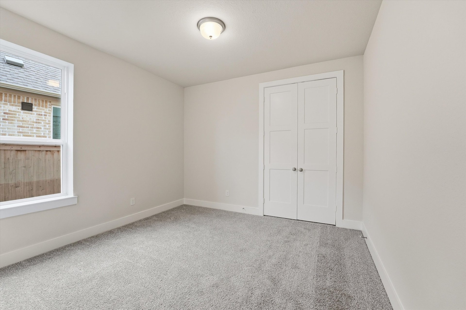 guest bedroom with carpet and window