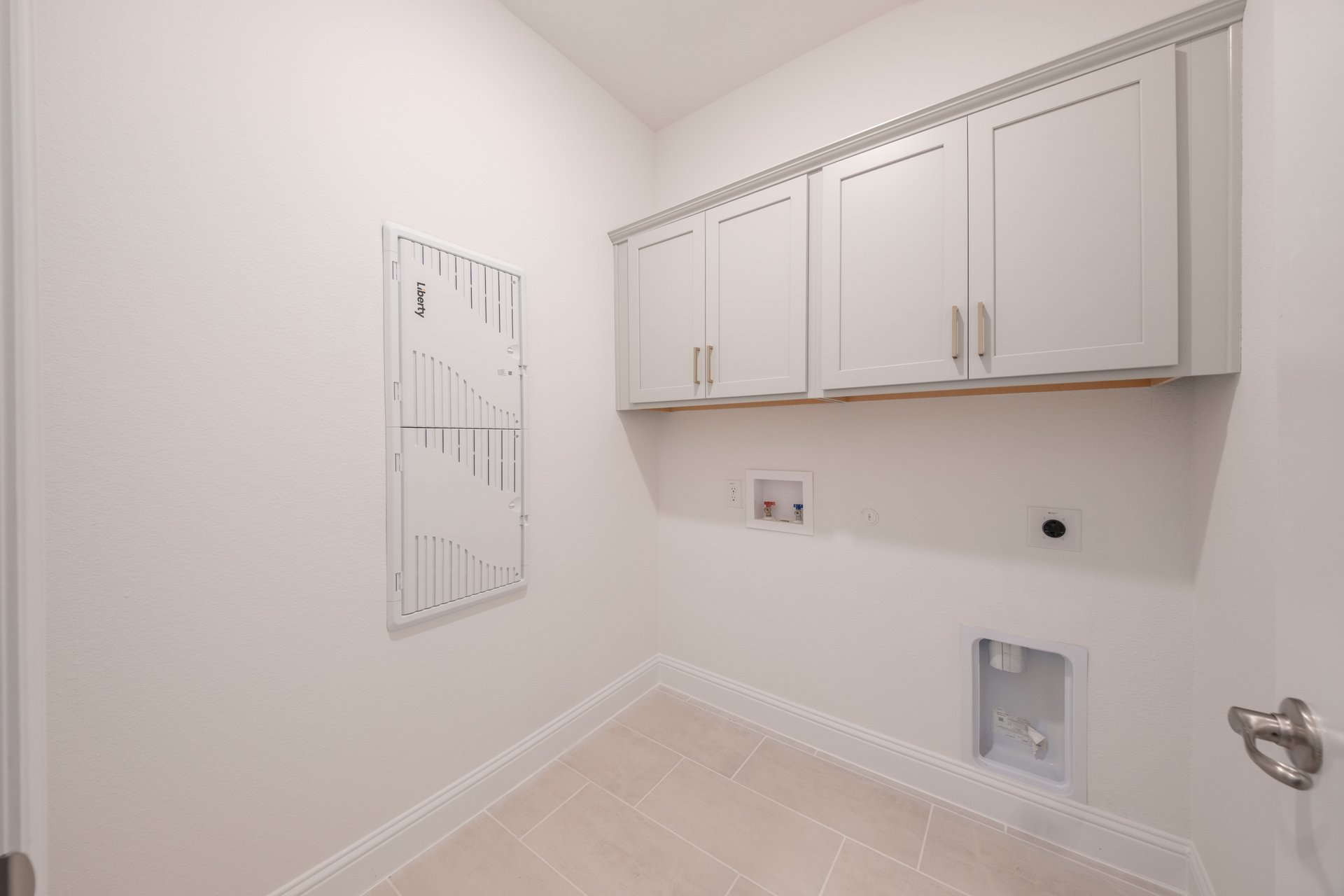 laundry room with tile flooring and storage shelf