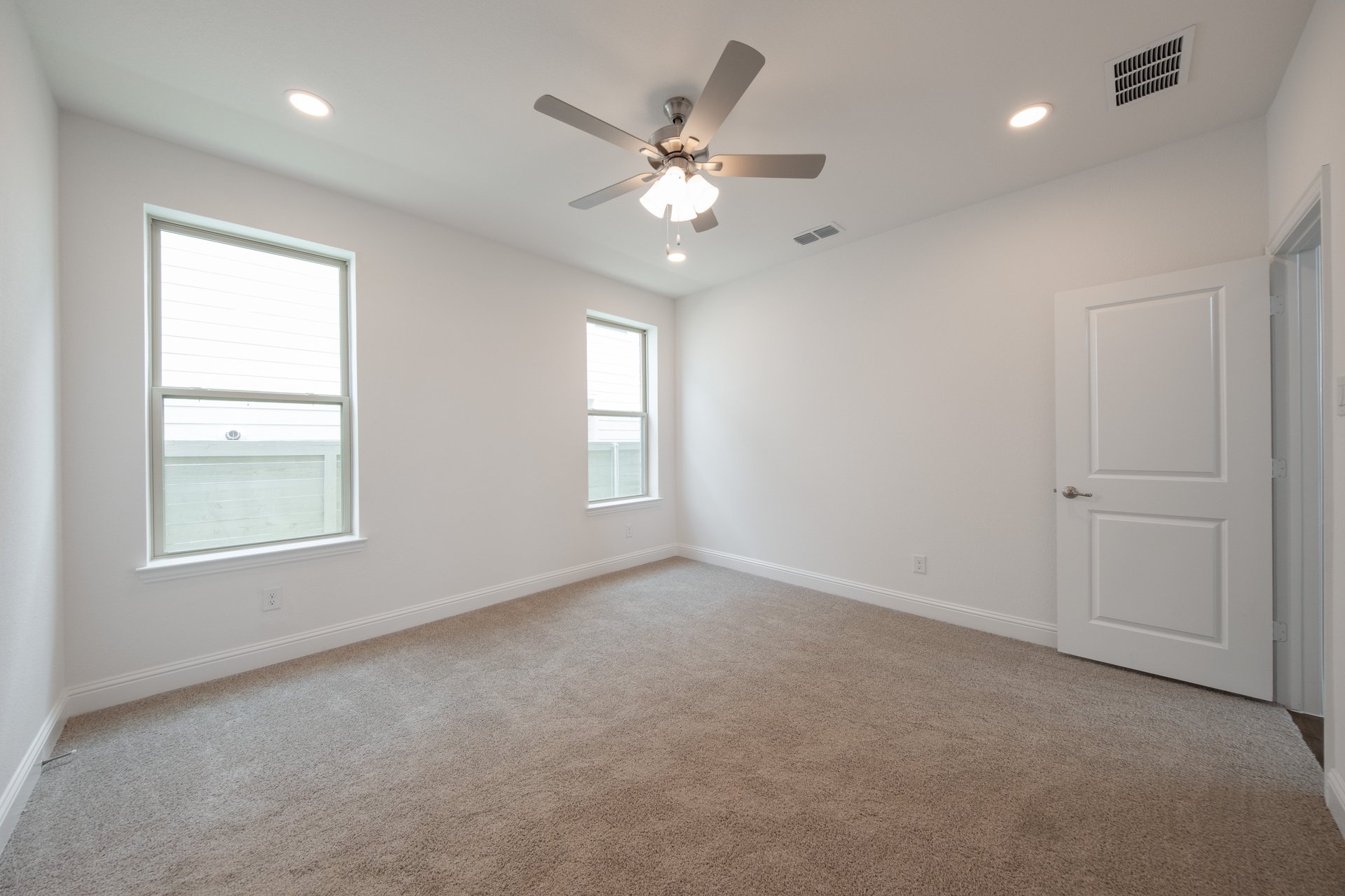 open primary bedroom with carpet and windows