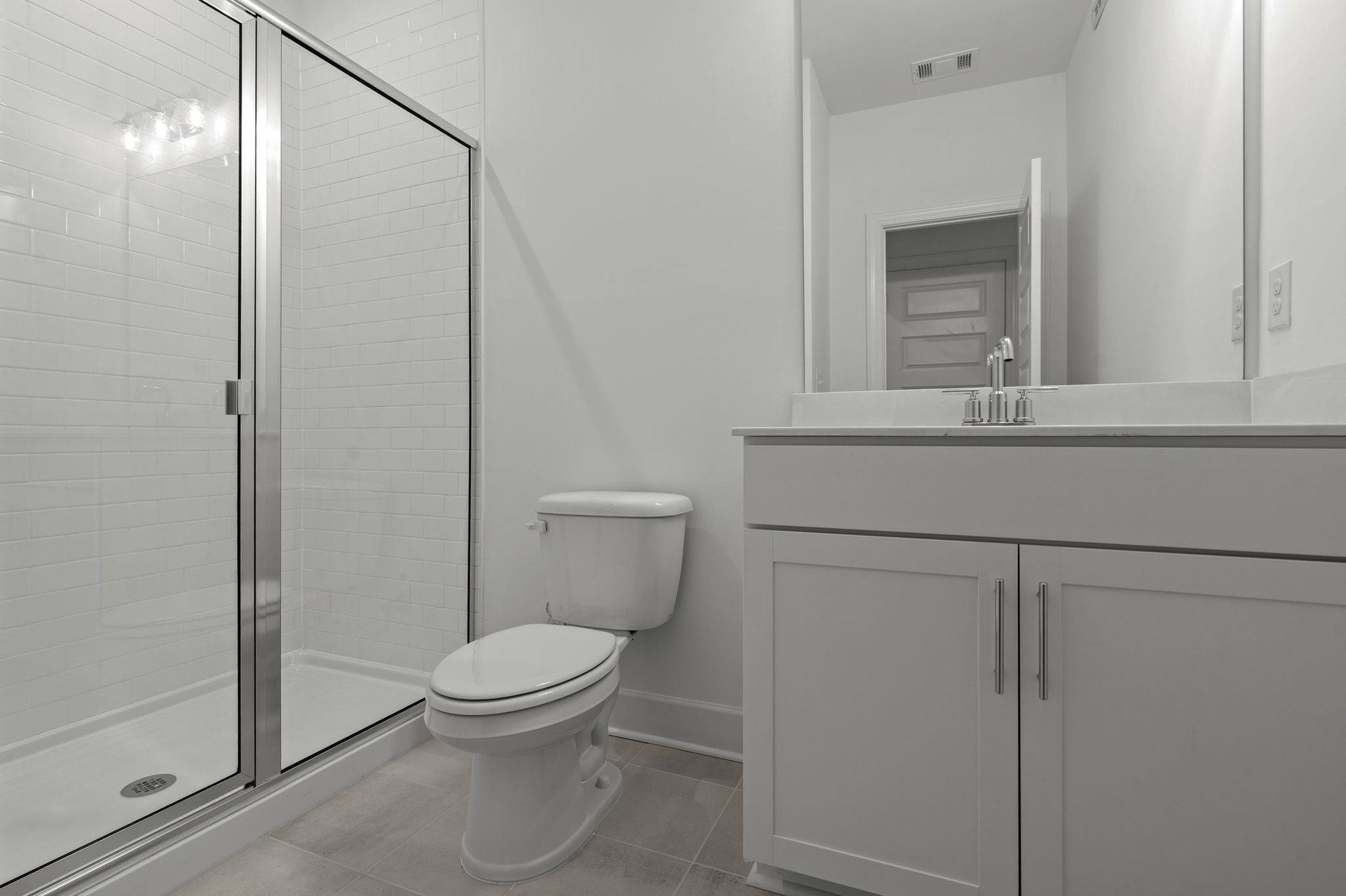 secondary bathroom with single sink vanity and a walk in shower