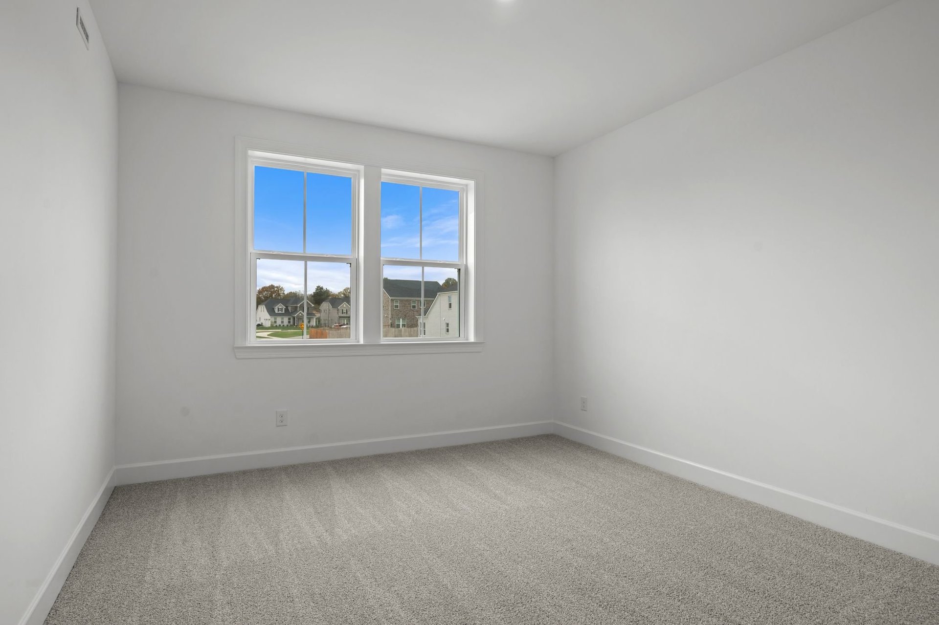 secondary bedroom with carpet flooring and large windows