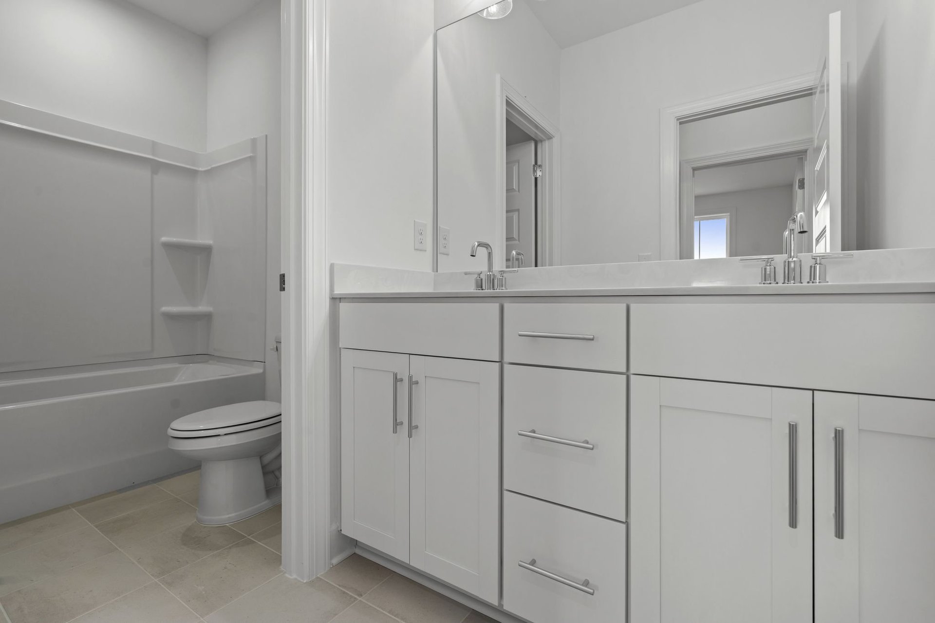 secondary bathroom with double sink vanity and a shower and tub combination