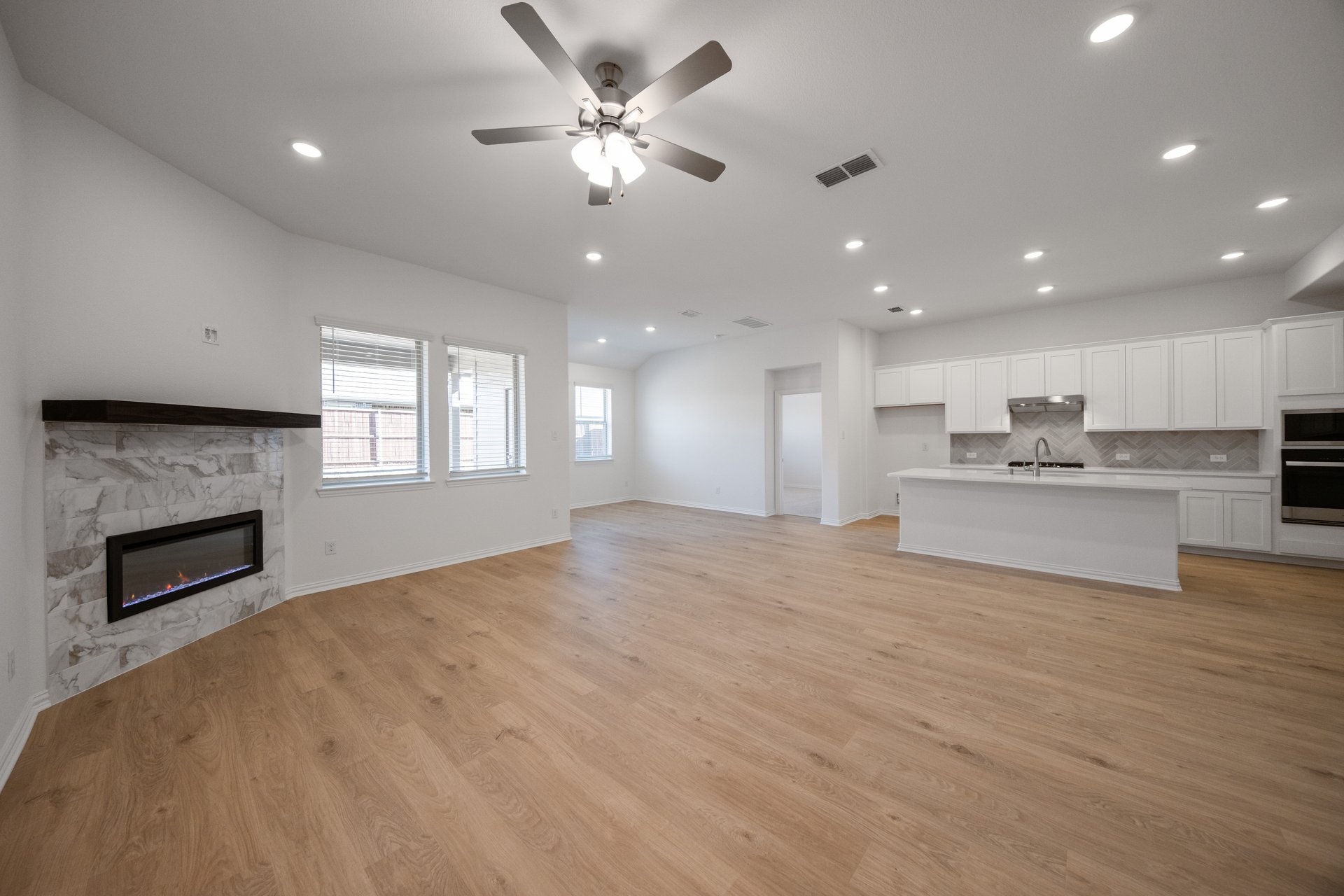 open great room with wood floors and fireplace