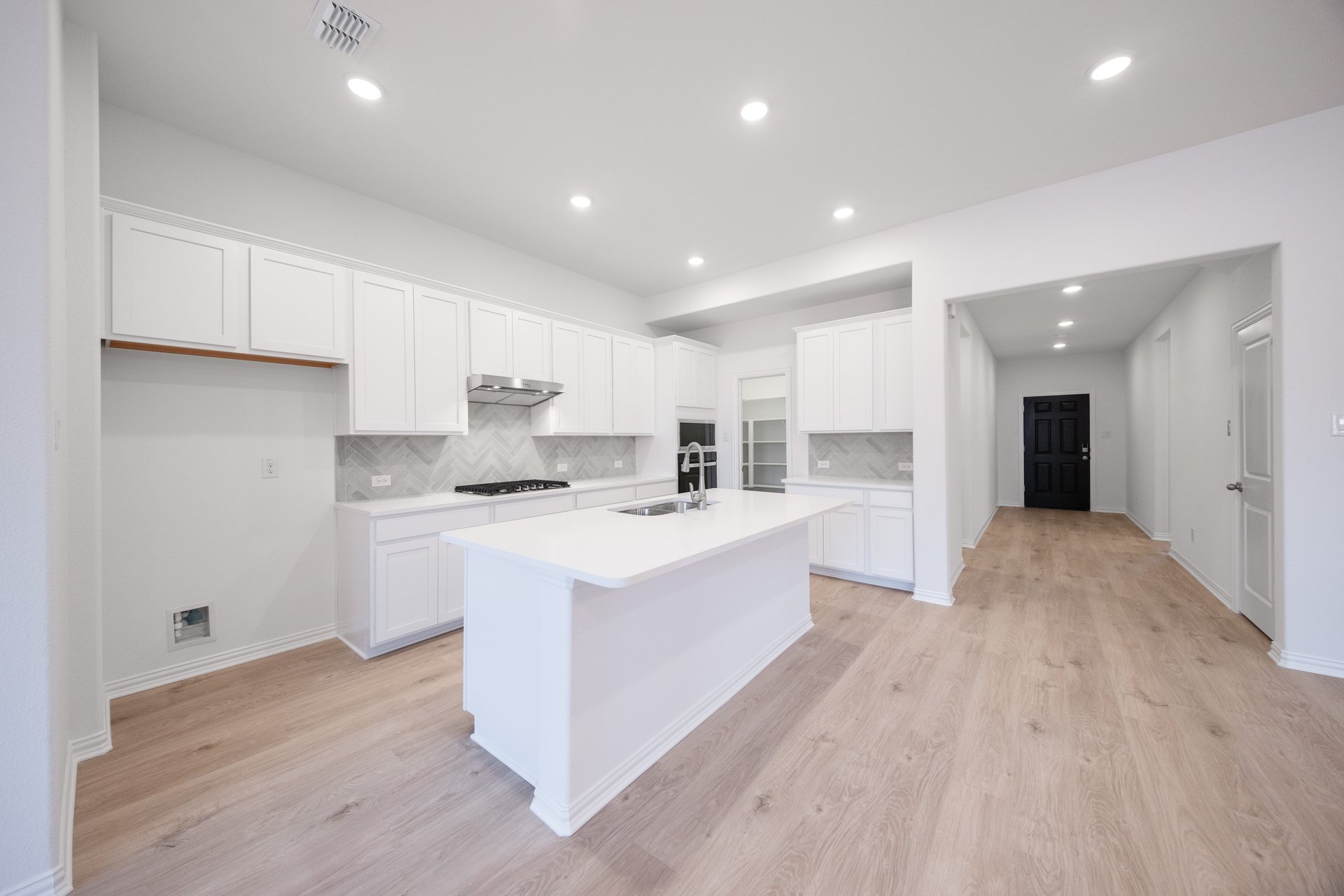 open kitchen with wood floors and white cabinets