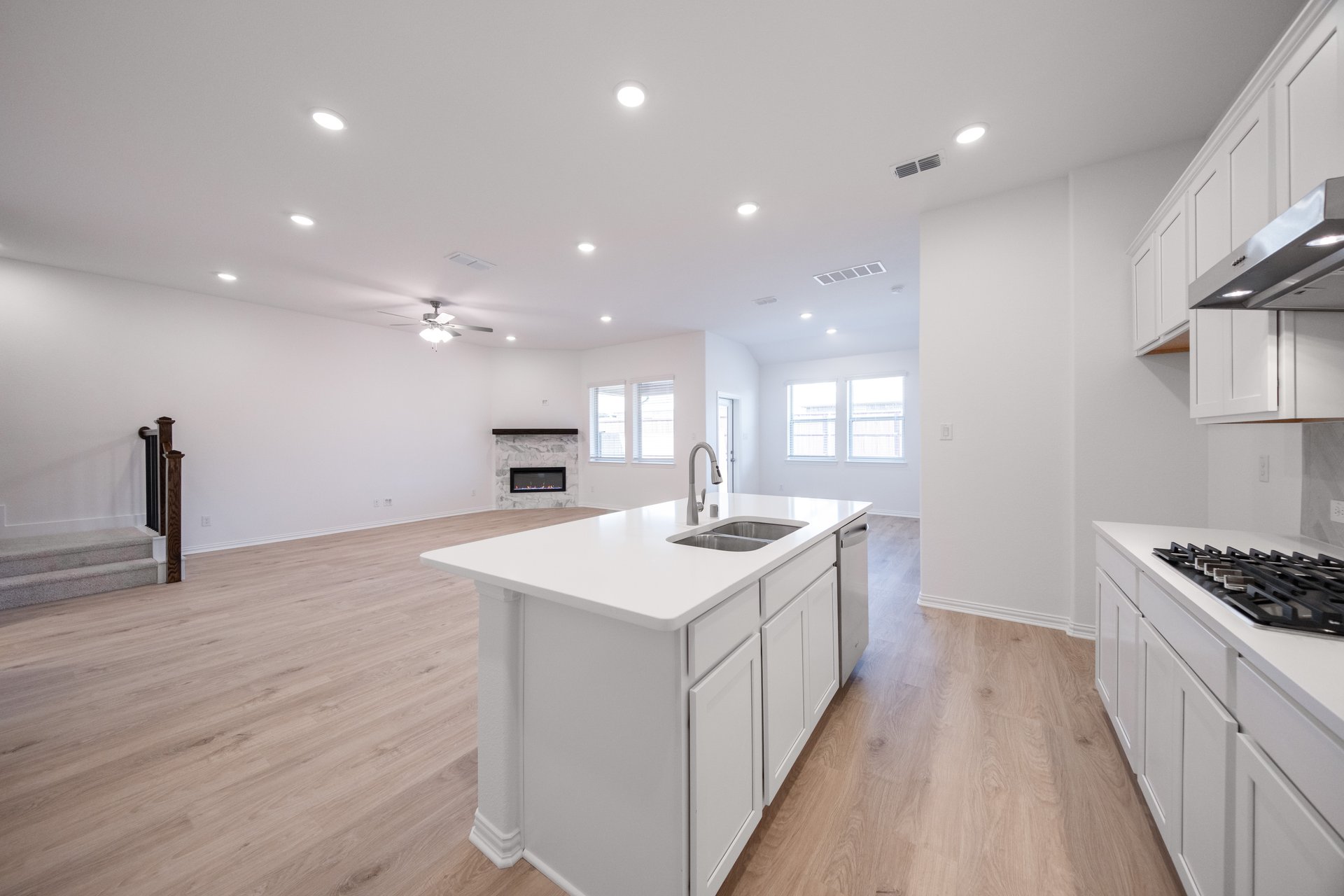 open kitchen with wood floors and white cabinets