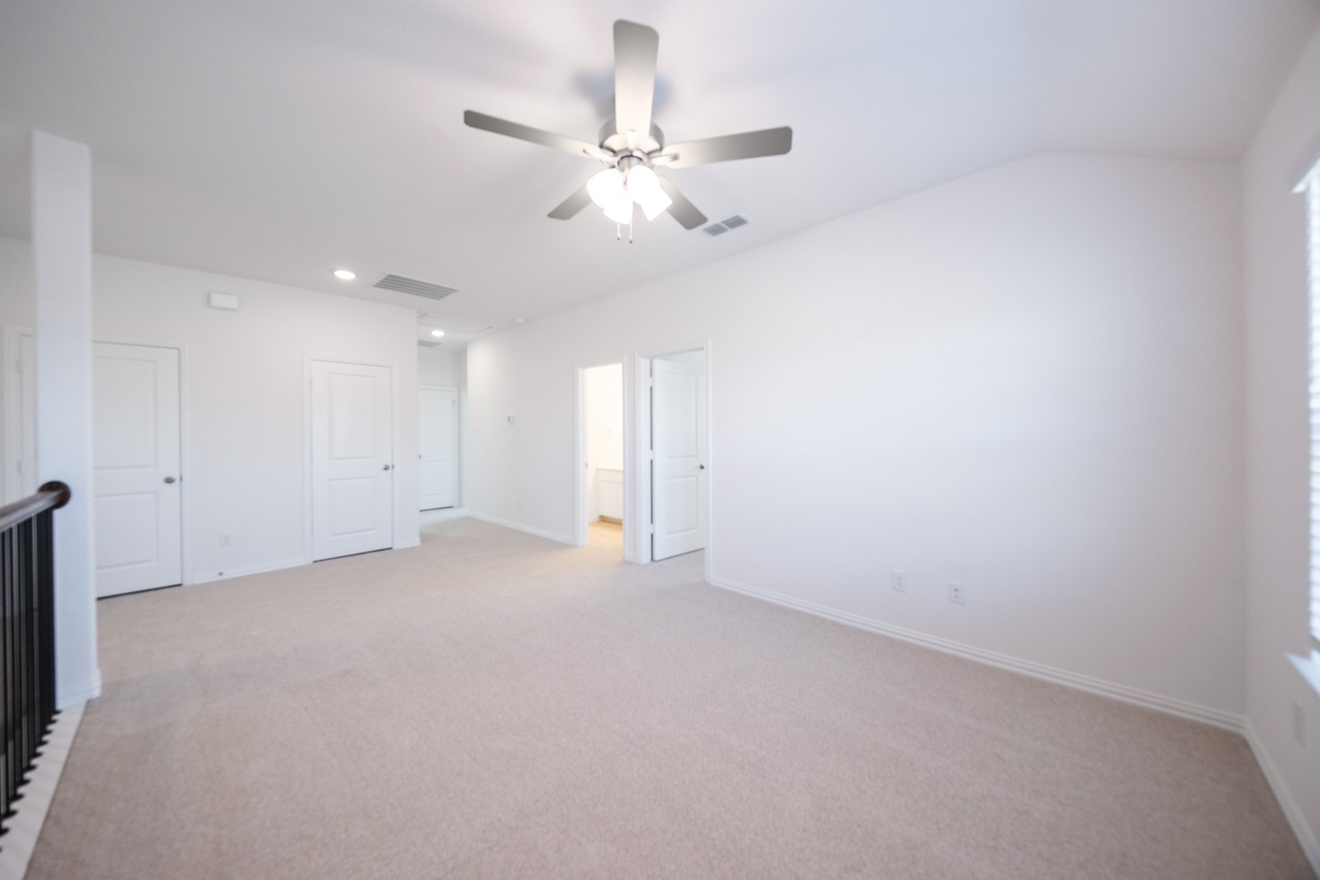 open loft with carpet and ceiling fan