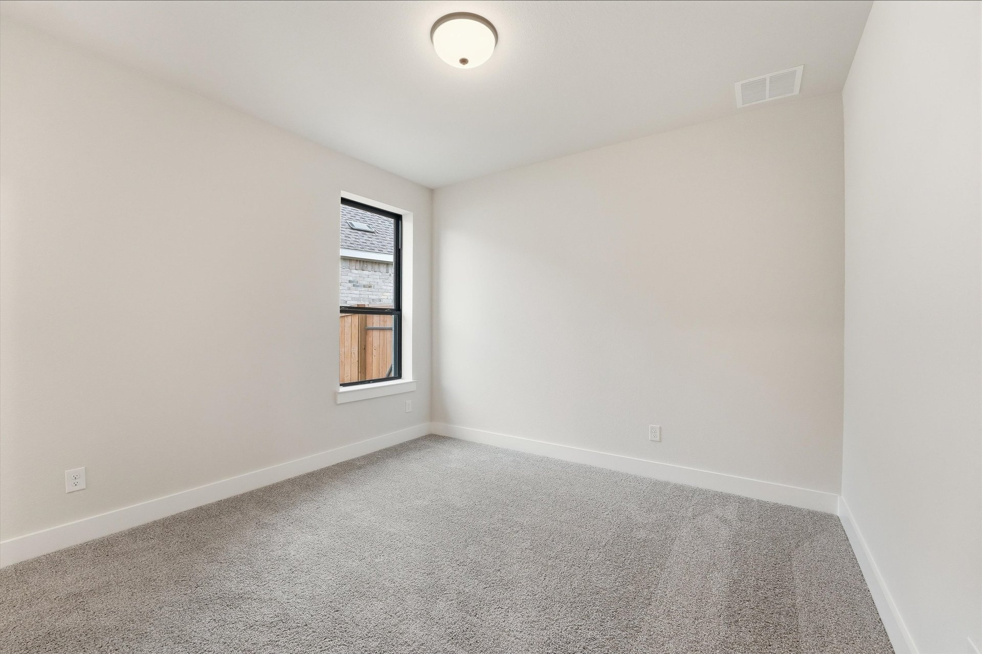 guest bedroom with window and carpet