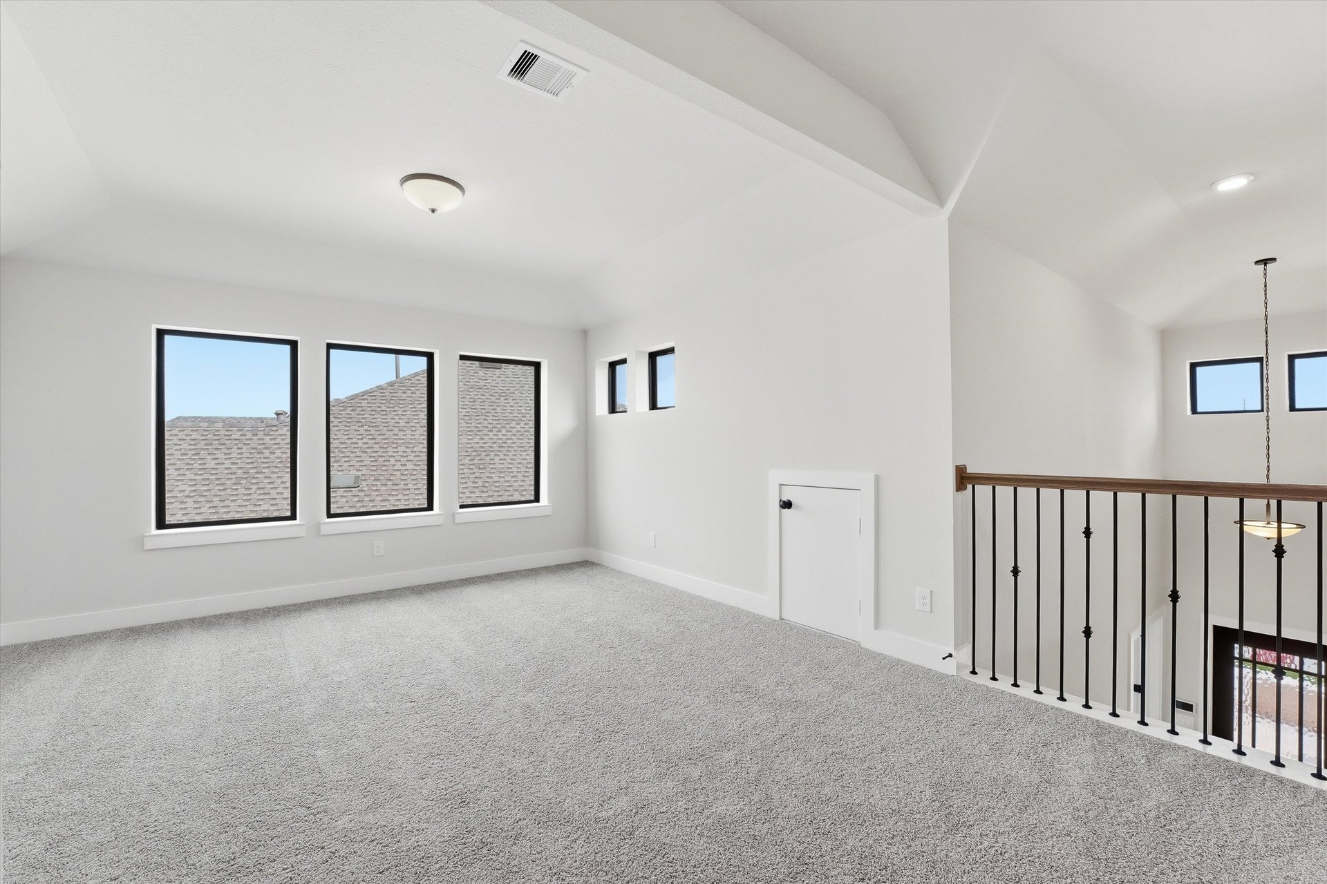 open loft with windows and carpet