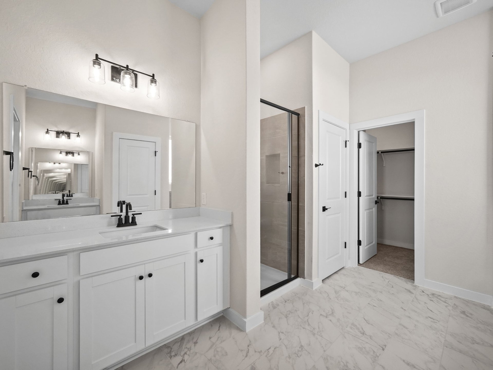 primary bathroom with white flooring, sink and walk-in shower