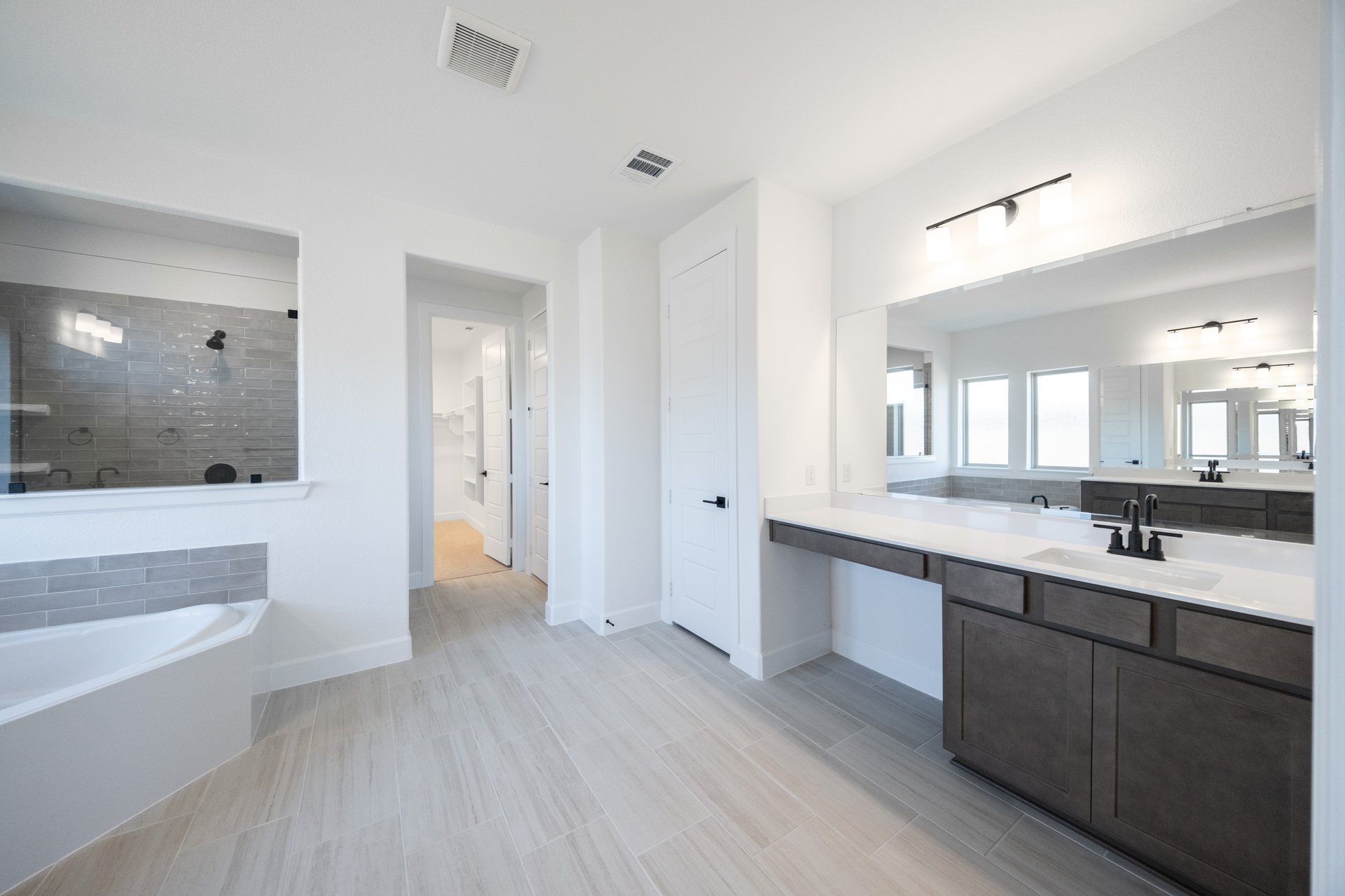 bathroom with large soaking tub and white countertops