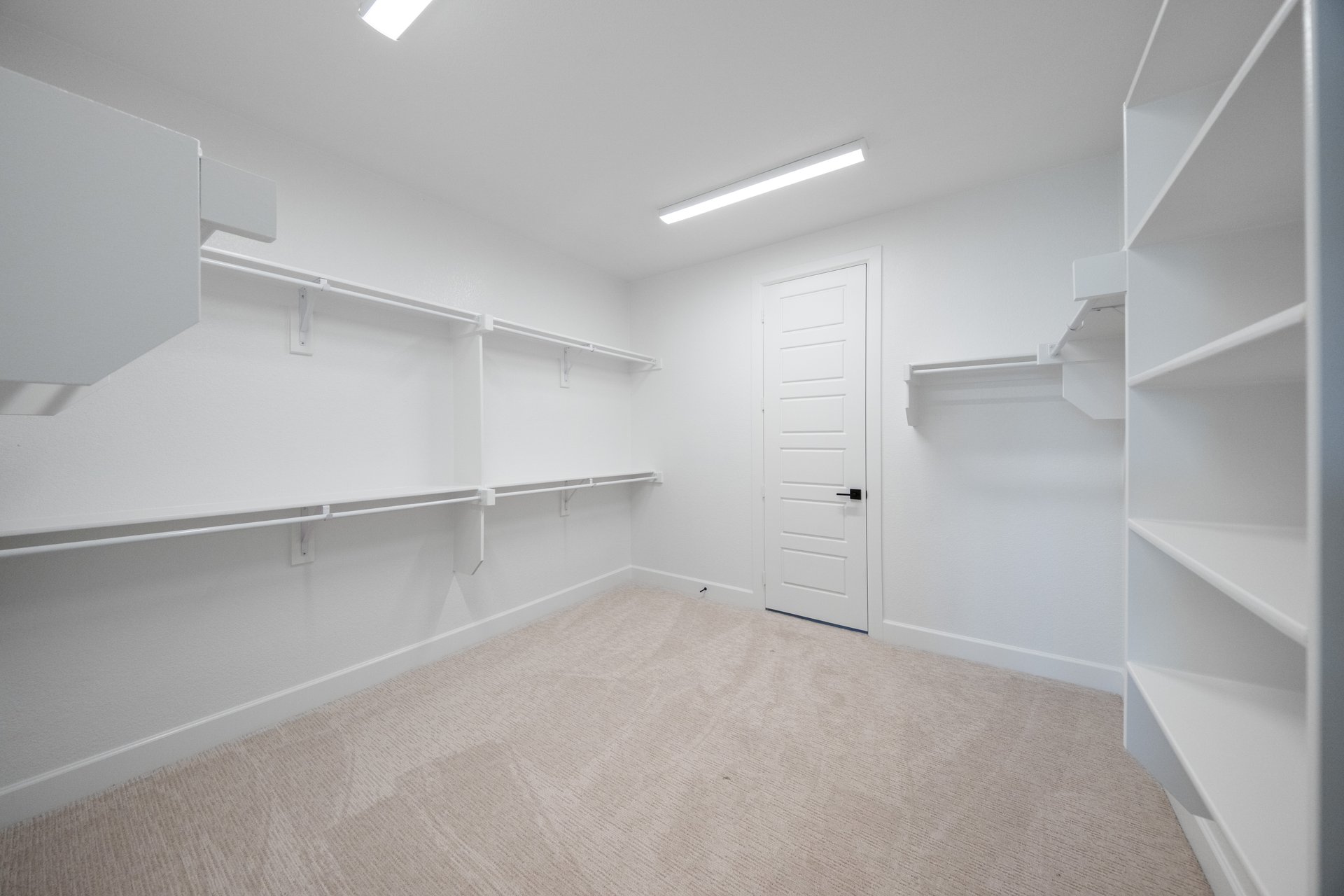 large closet with hanging racks and shelves