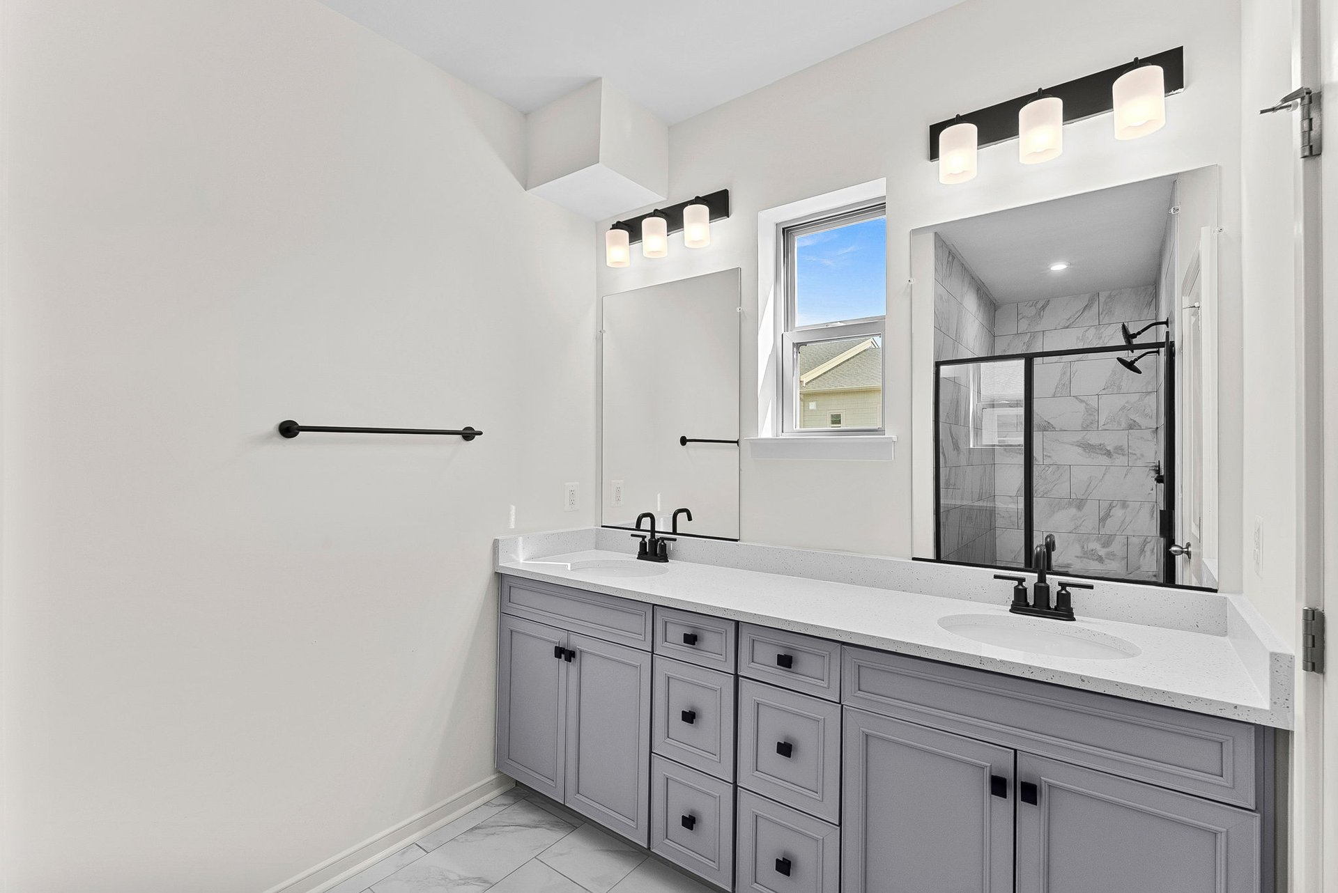 primary bathroom with two sinks and an oversized shower