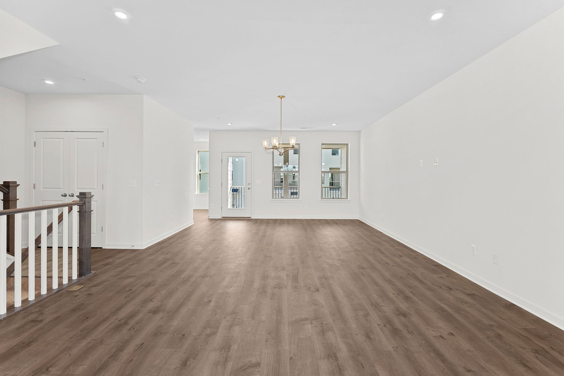great room with stair railing and hardwood floors