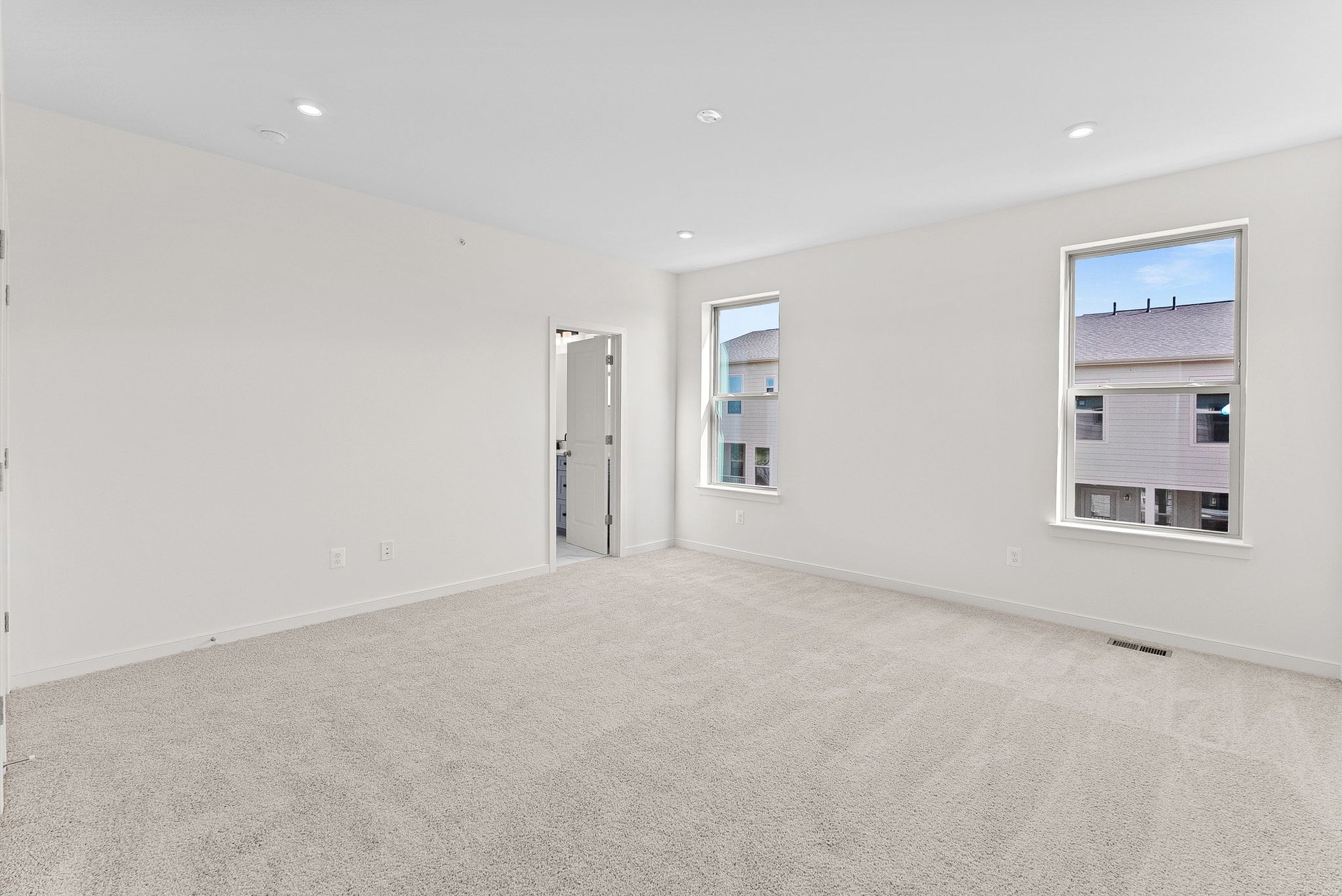 secondary bedroom with carpet and two windows